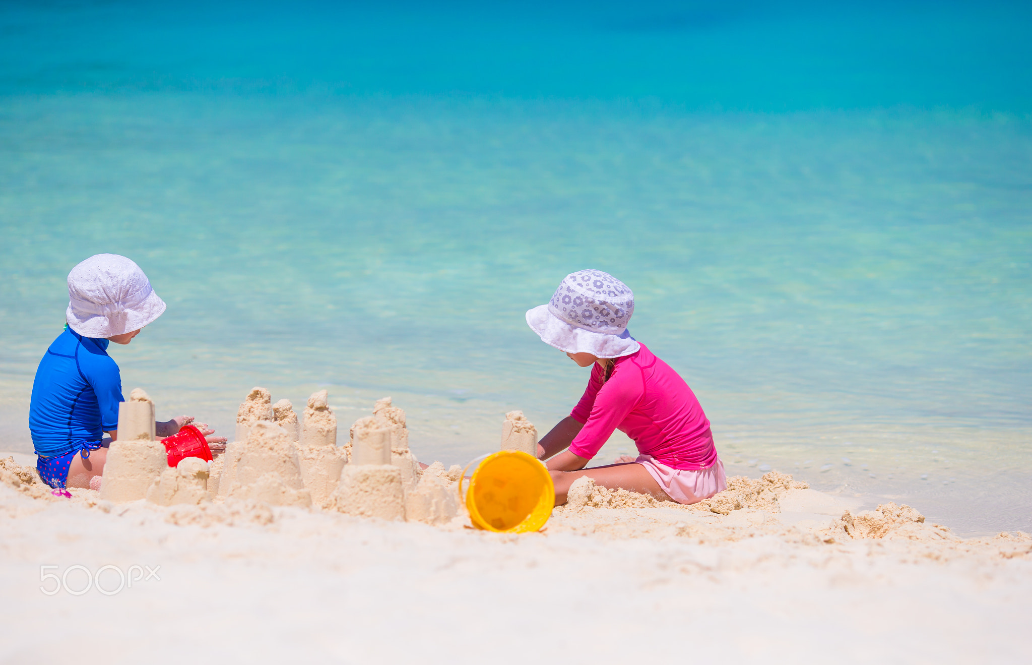 Little girls playing with beach toys during tropical vacation