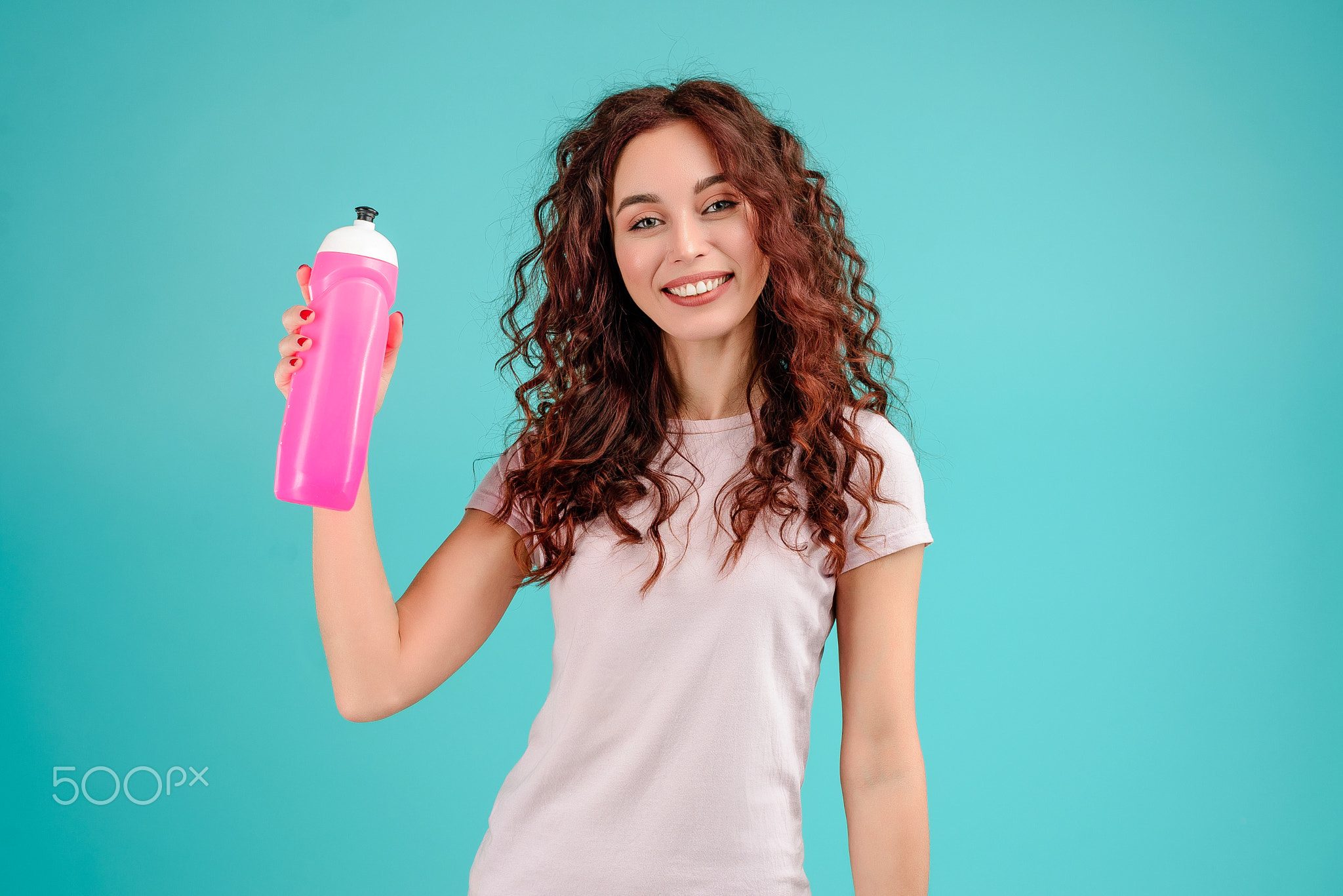 Young woman with curly hair isolated over bright colorful background