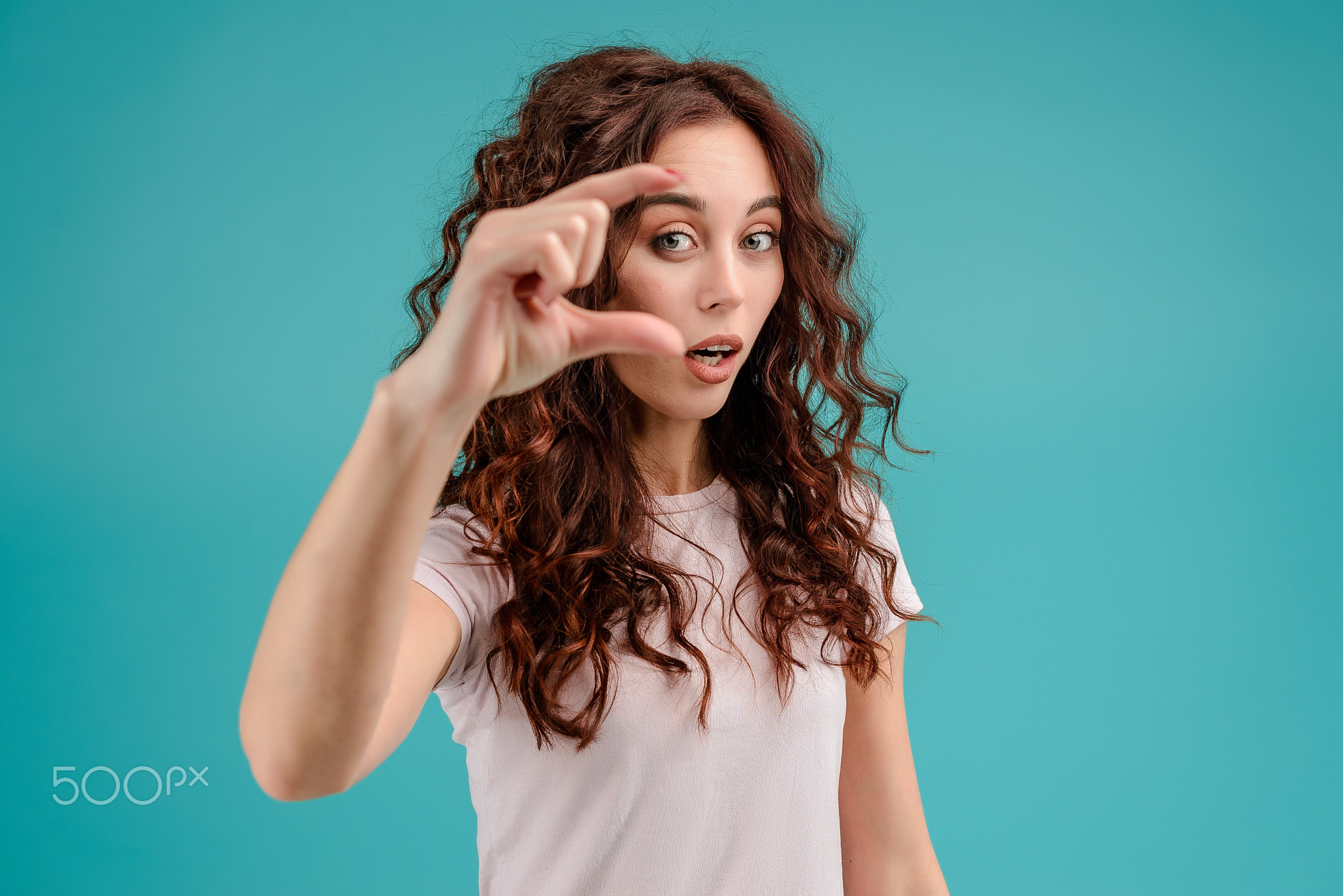 Young woman with curly hair isolated over bright colorful background