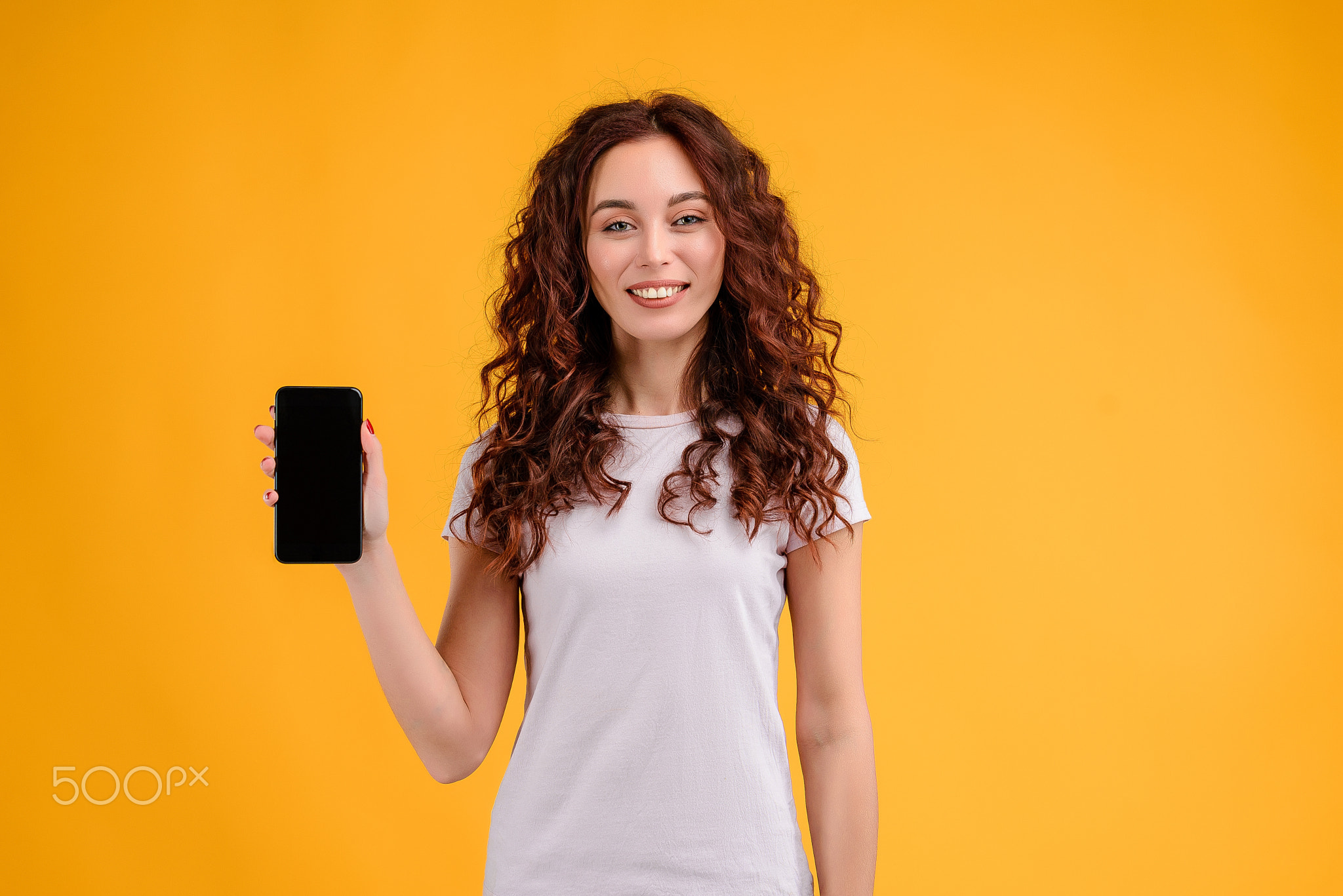 Young woman with curly hair isolated over bright colorful background