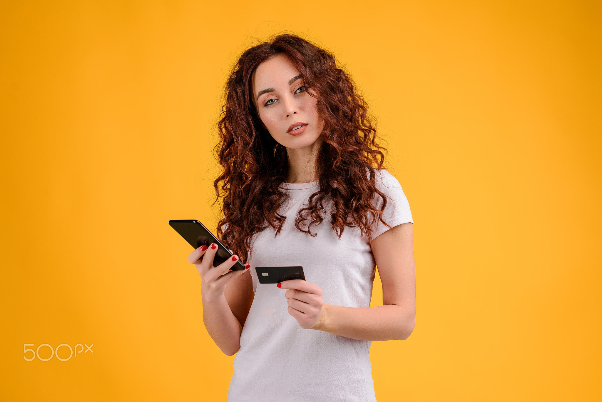 Young woman with curly hair isolated over bright colorful background