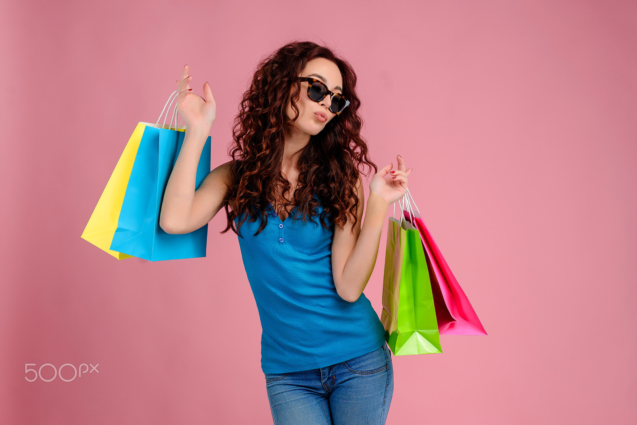 Young woman with curly hair isolated over bright colorful background