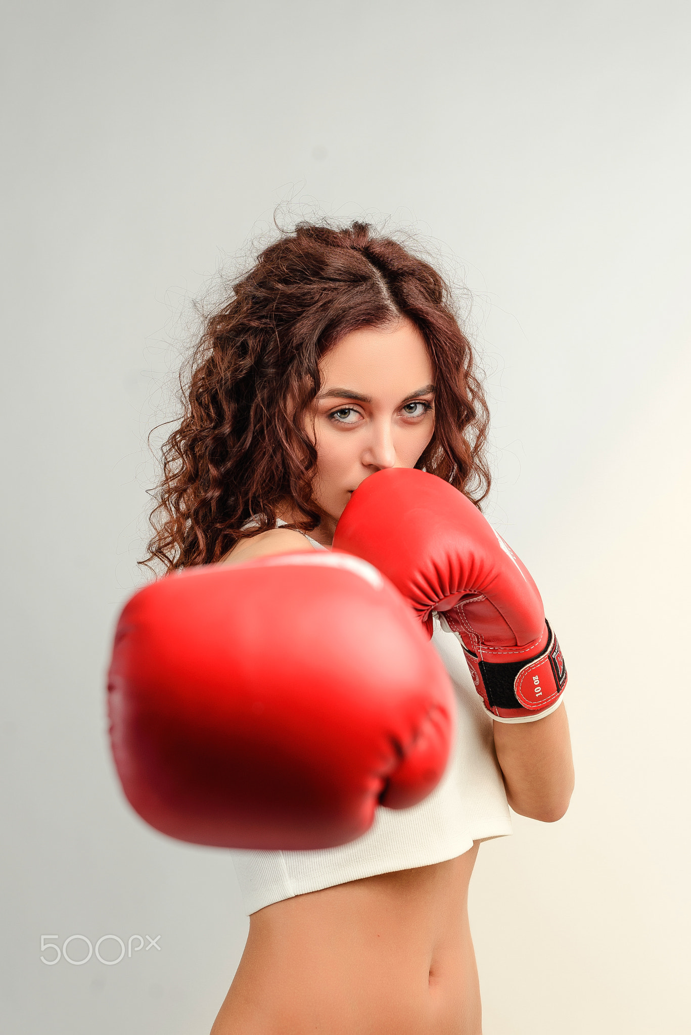 Young woman with curly hair isolated over bright colorful background