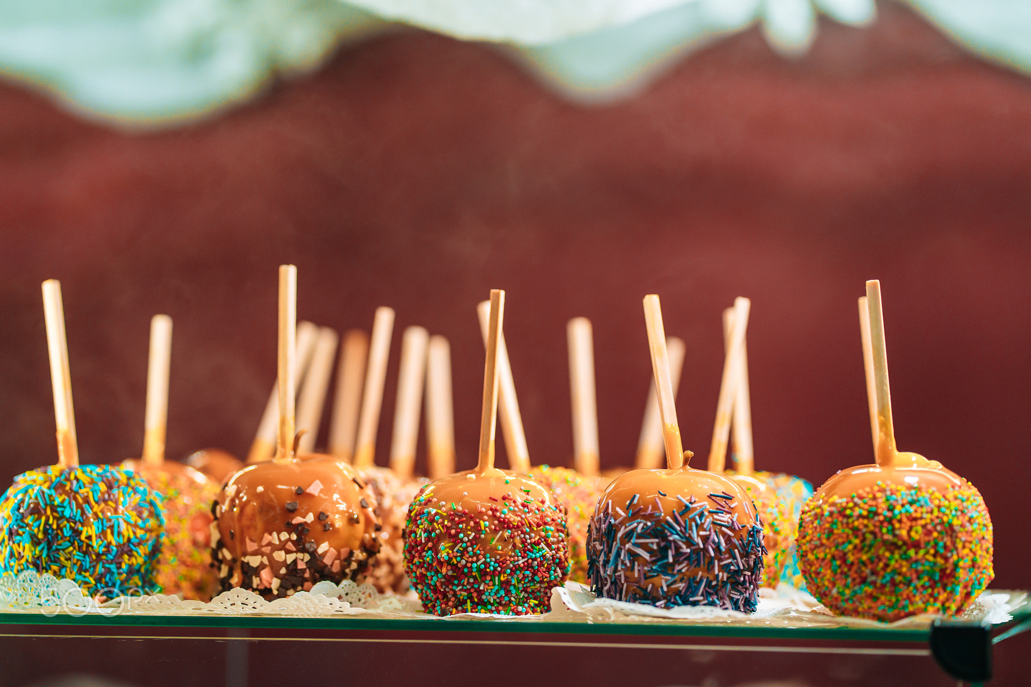 Apples in caramel and sprinkles. Street food.