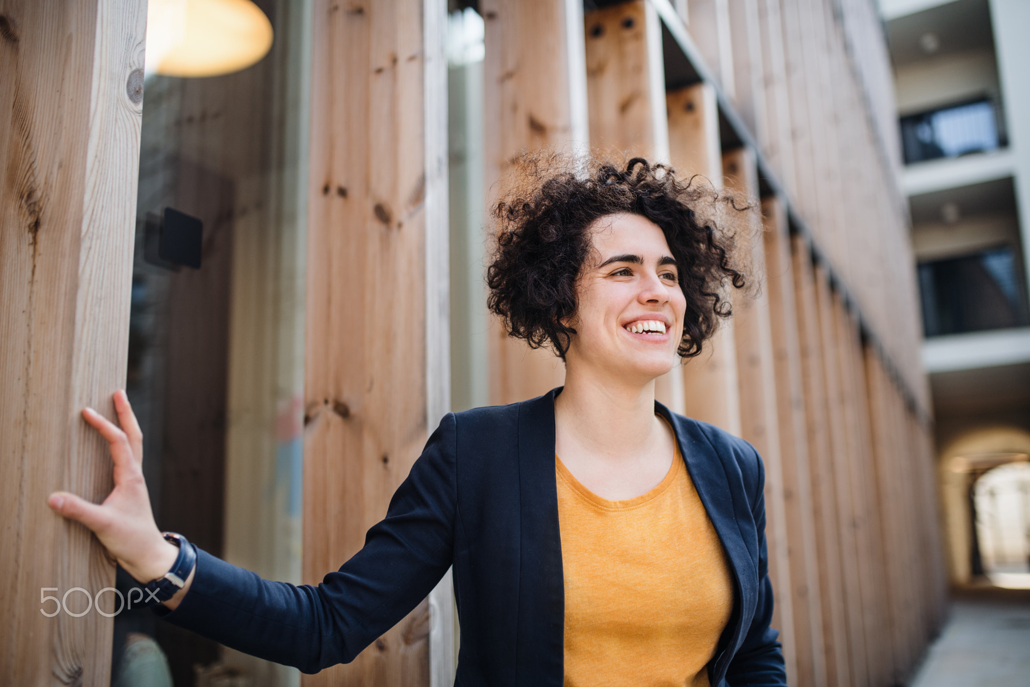 A happy young business woman standing outdoors, resting.