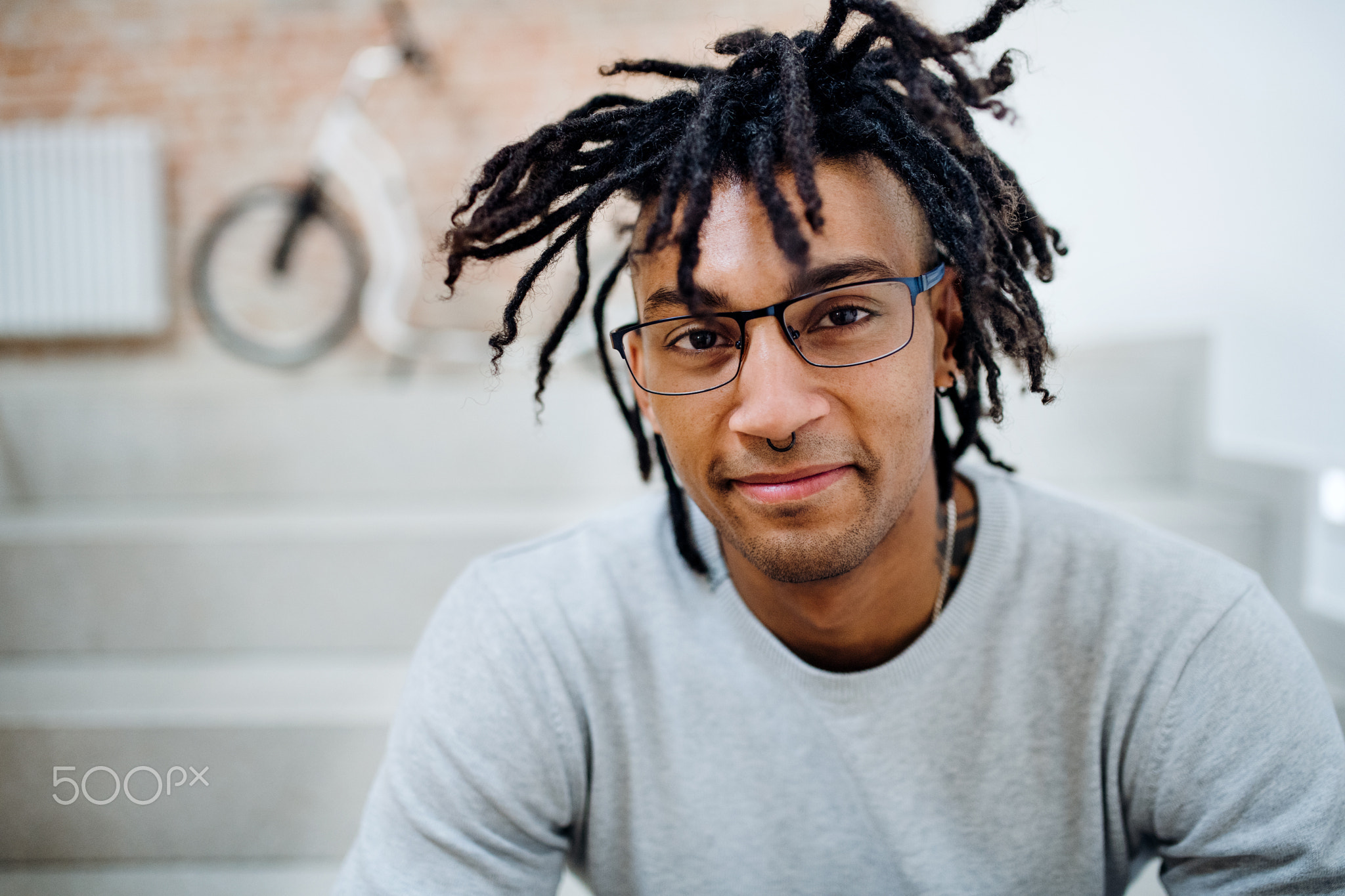 A young mixed race businessman with dreadlocks in office.