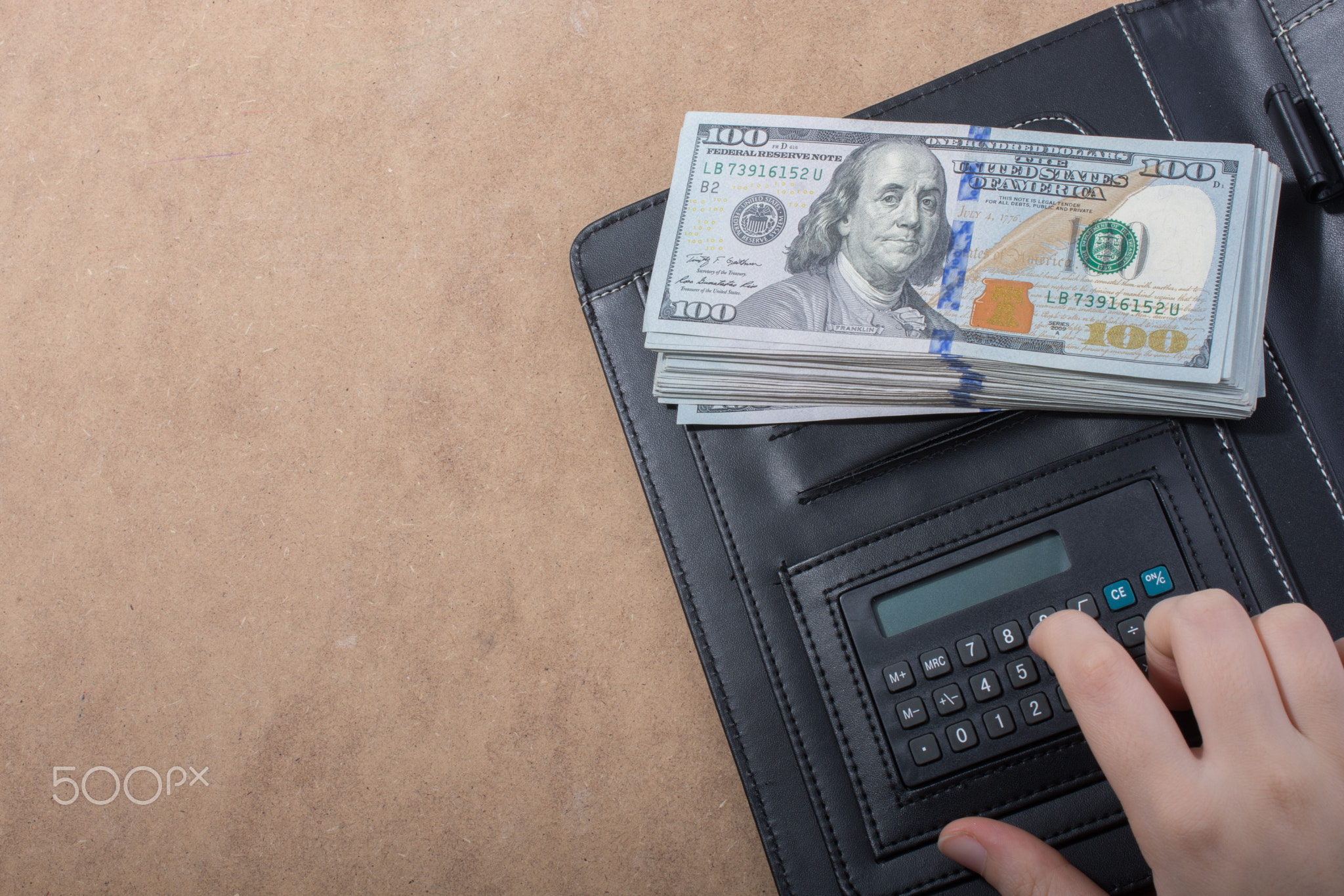 Hand holding American dollar isolated on wooden background