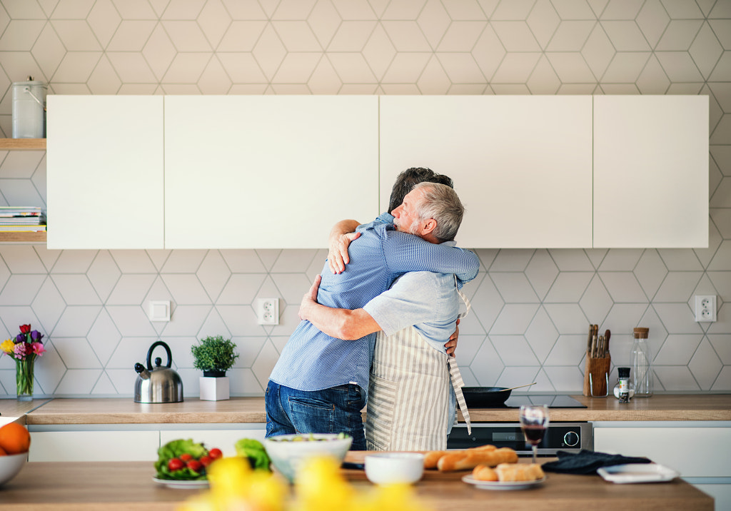An adult hipster son and senior father indoors at home, hugging when cooking. by Jozef Polc on 500px.com