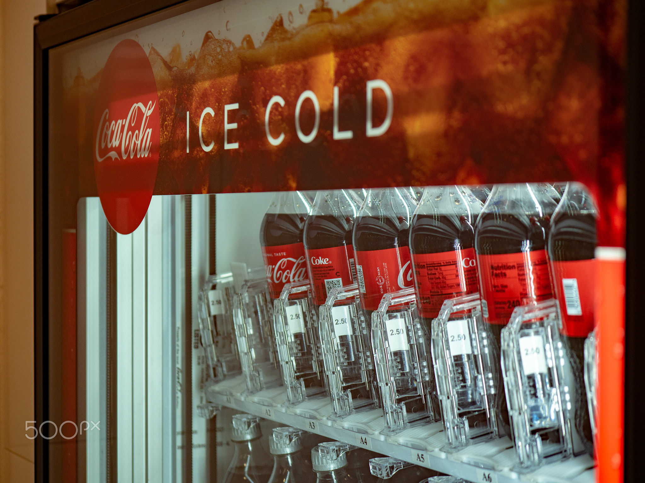 Coca Cola ice cold logo filled with bottles inside a vending machine