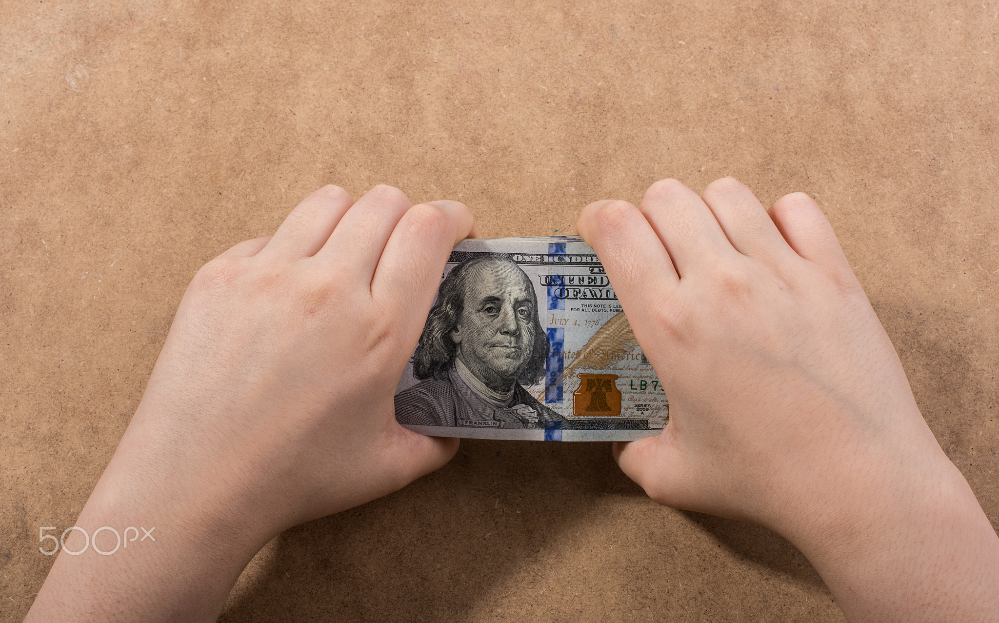 Hand holding American dollar isolated on wooden background