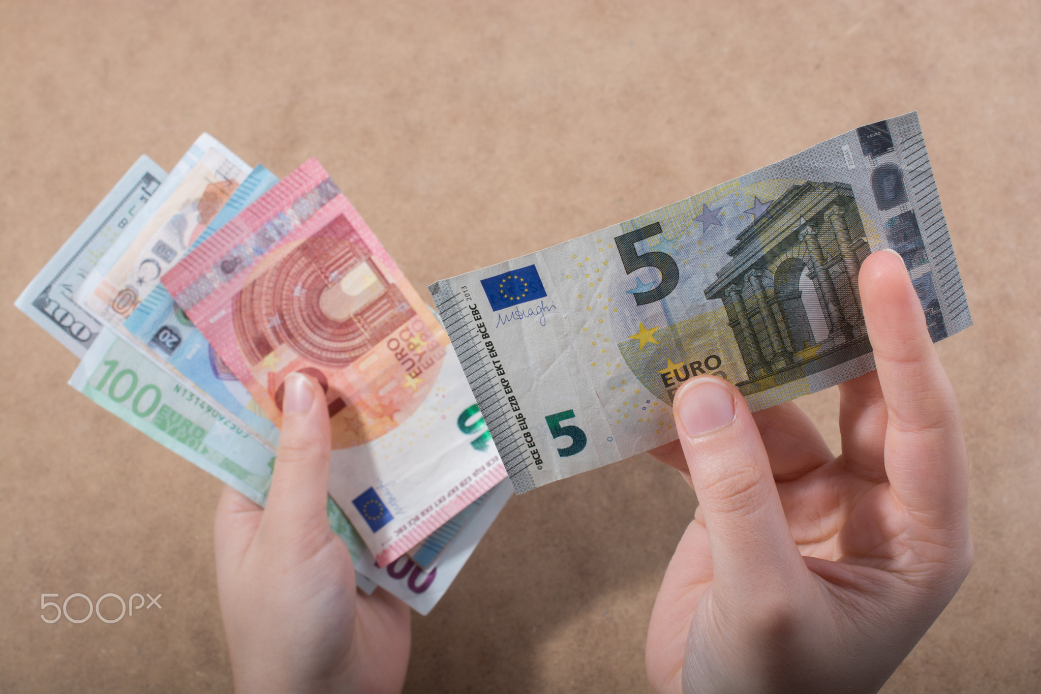 Hand holding American dollar isolated on wooden background