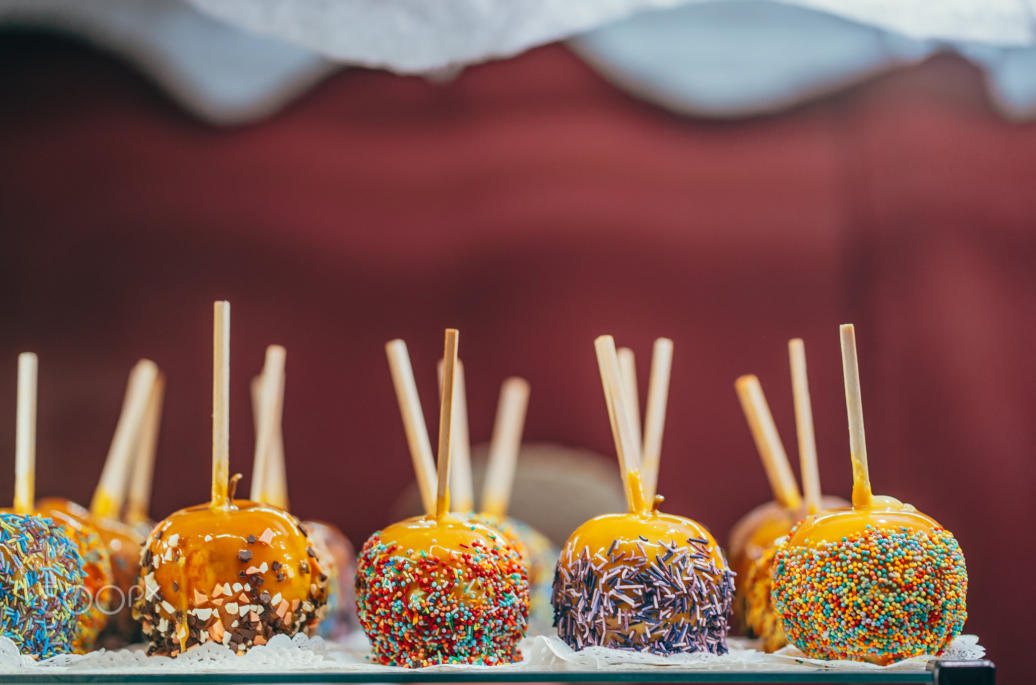 Apples in caramel and sprinkles. Street food.