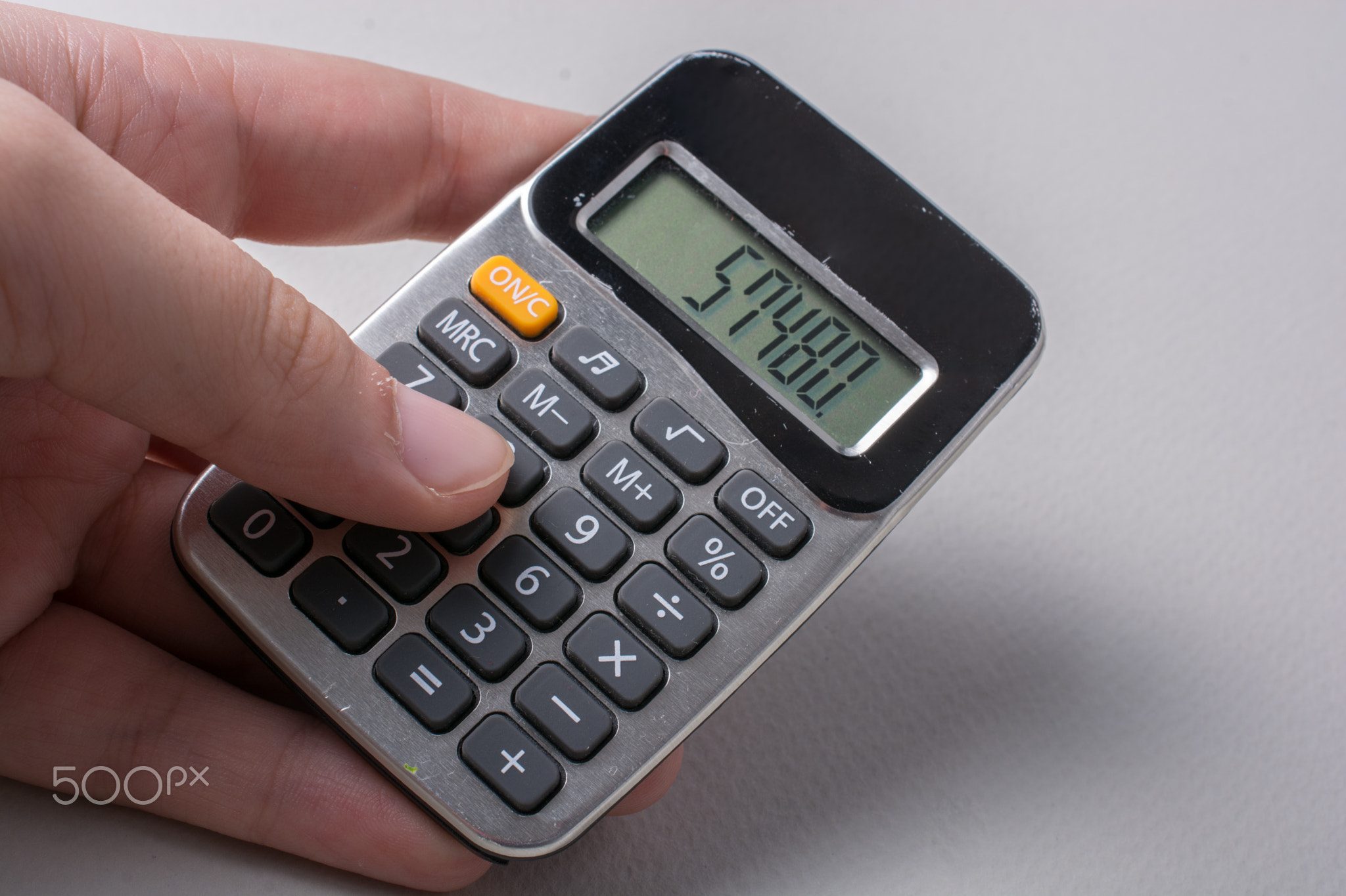 Hand holding a calculator in hand