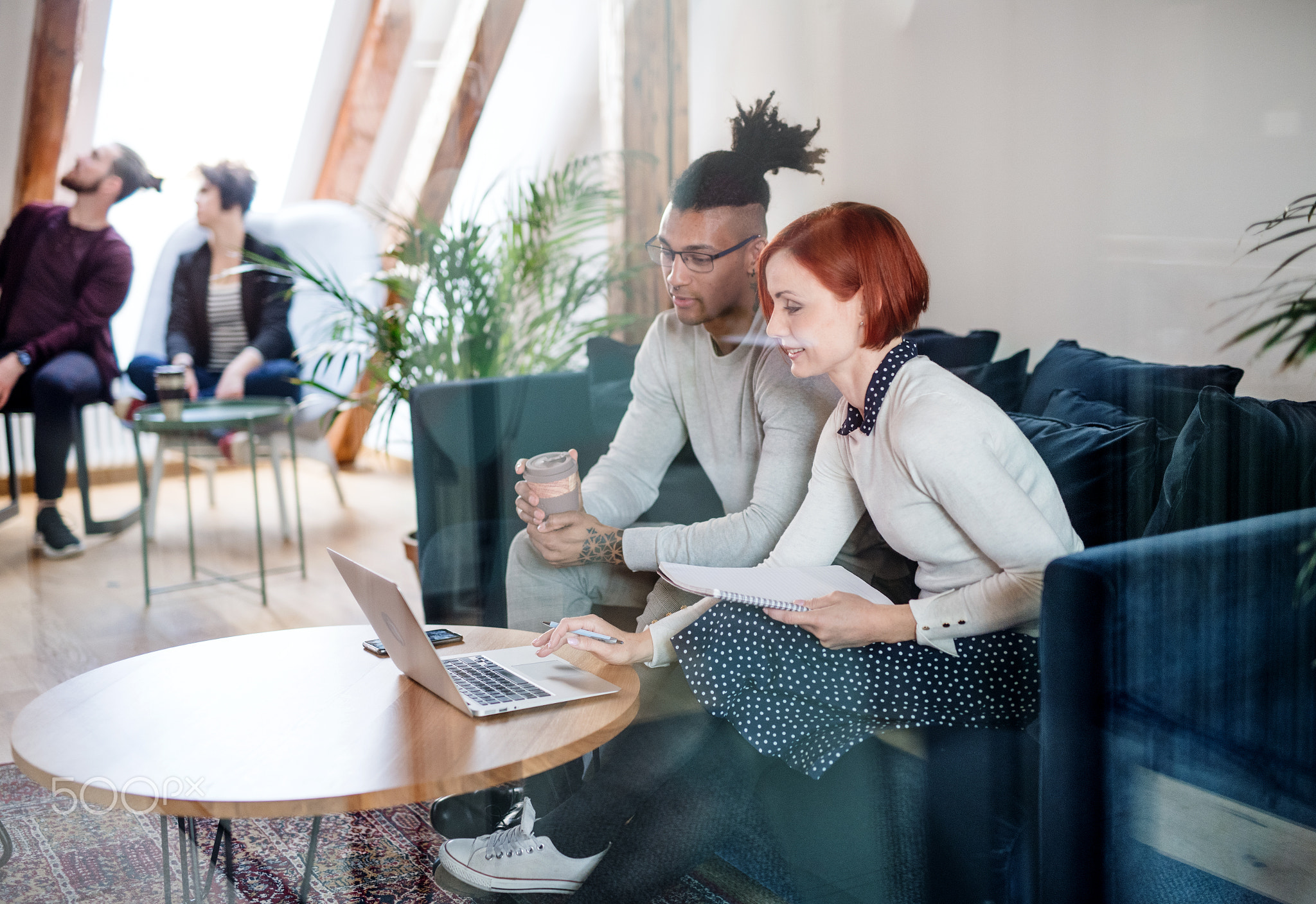 Group of young businesspeople using laptop in office, start-up concept.