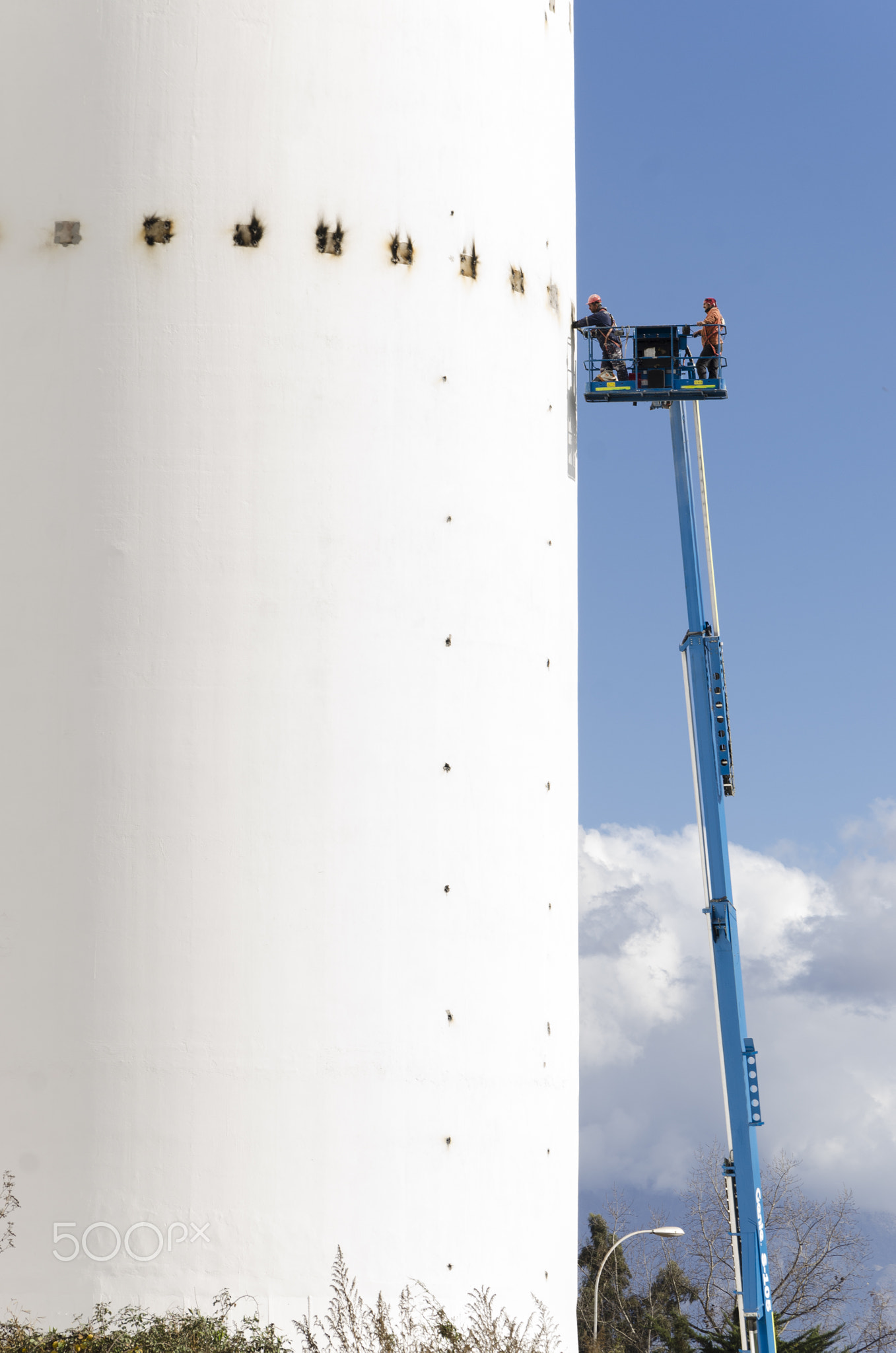 work in height in water tower, workers in a crane