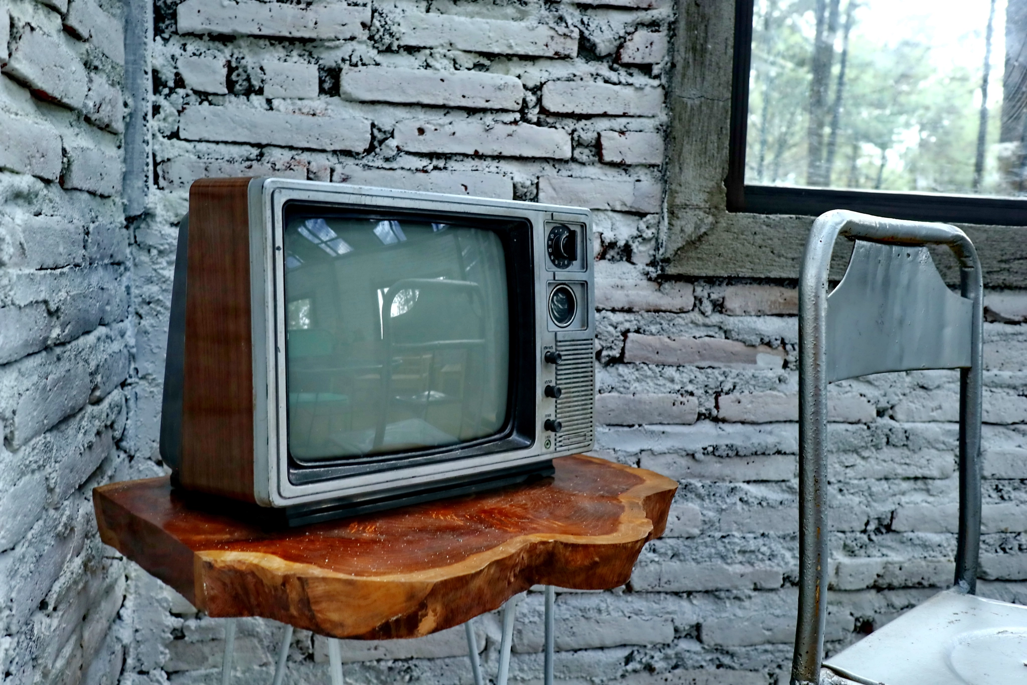 a room with an old iron chair and television