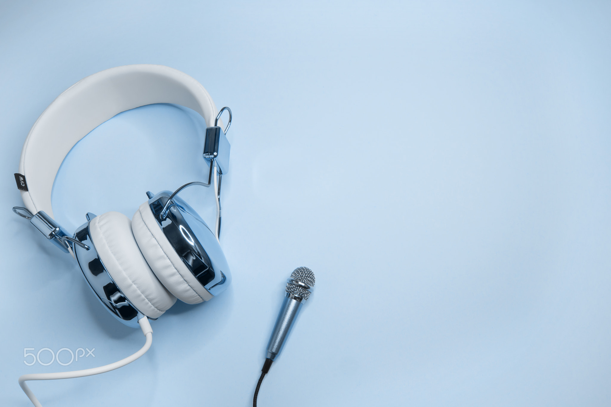 Music background with blue headphones and microphone.