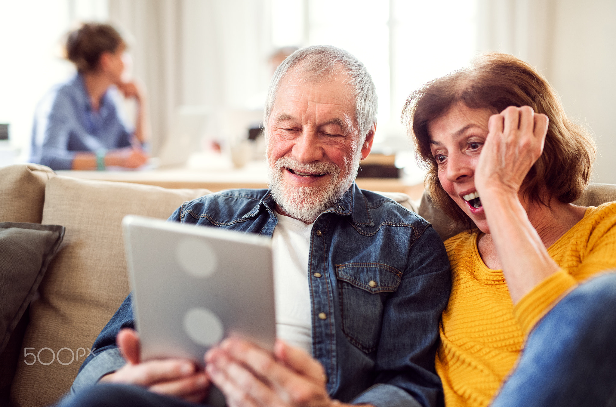 Senior couple using tablet in community center club.