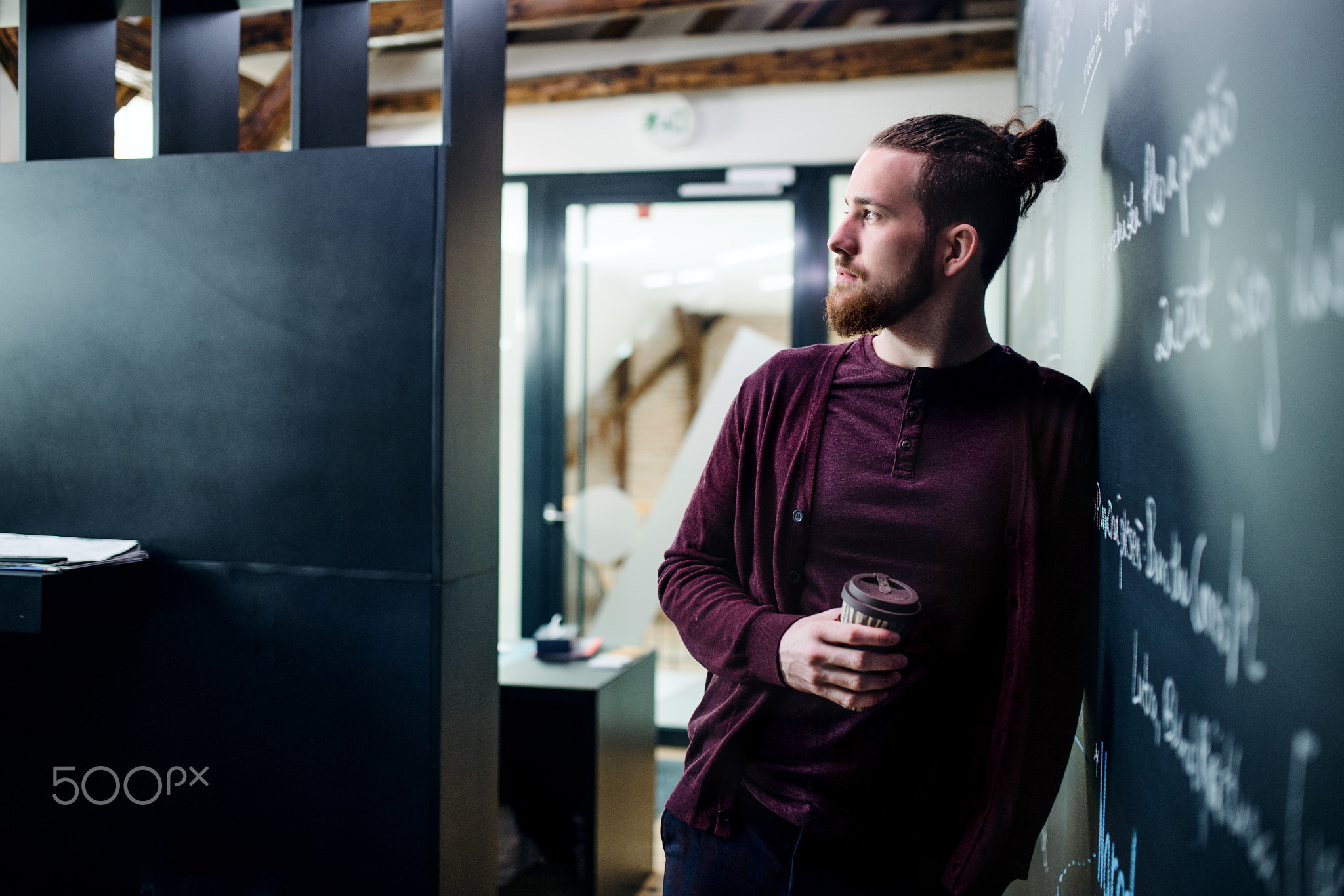 Young businessman with coffee in office, having a break.