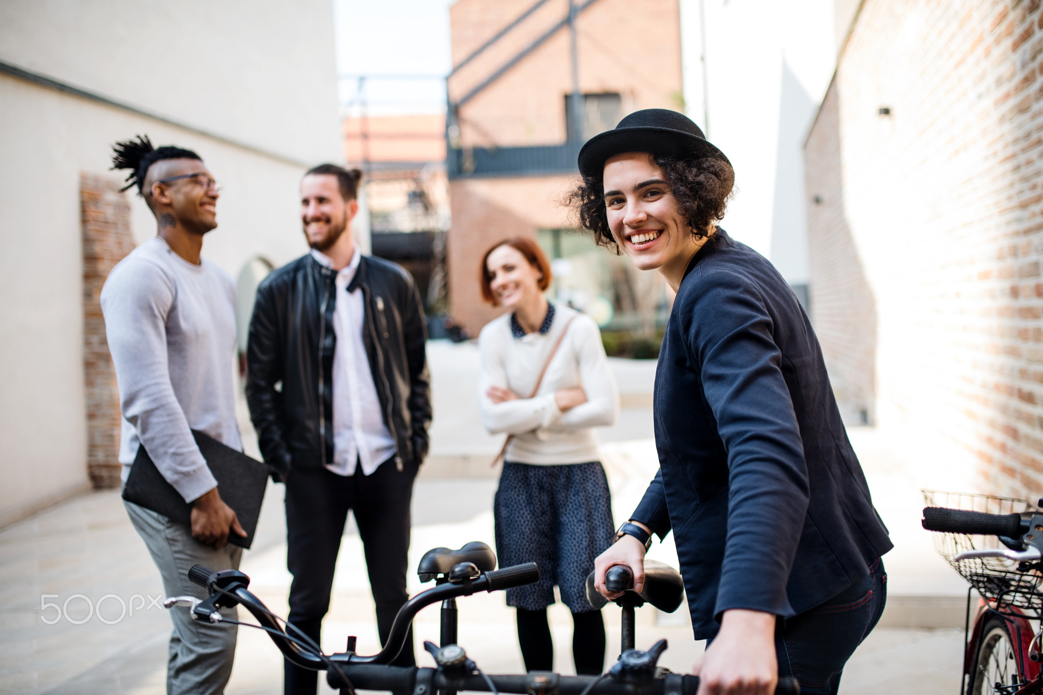 A happy young business people with bicycle standing outdoors.