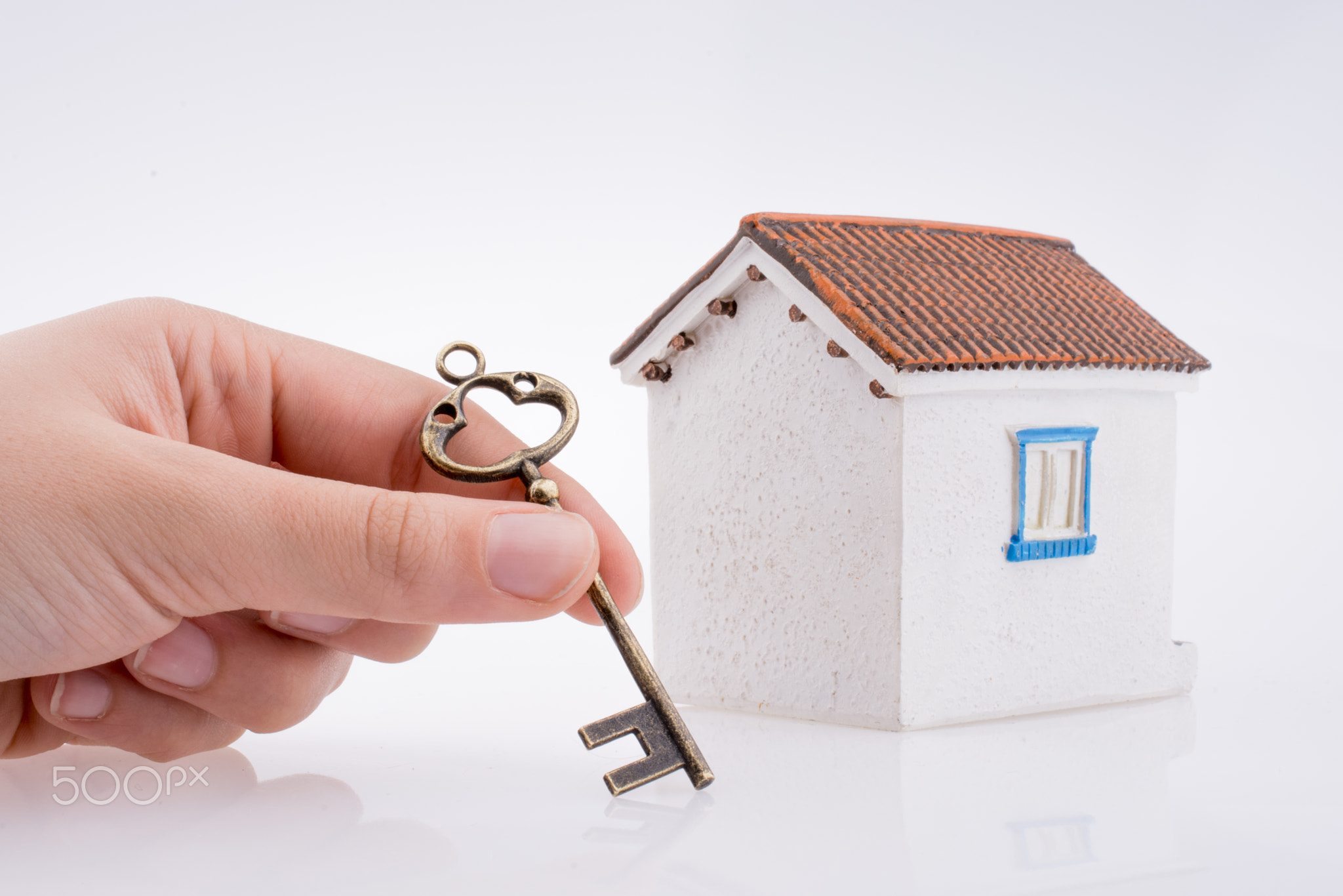 Hand holding a key near a house