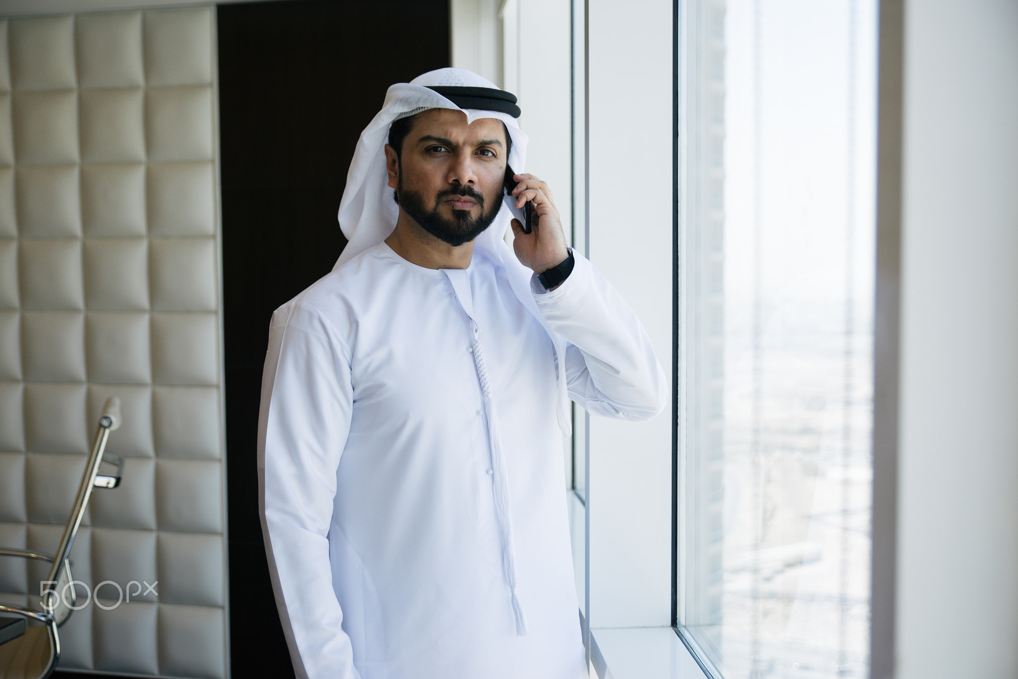 Arabic businessman looking out the window in his office