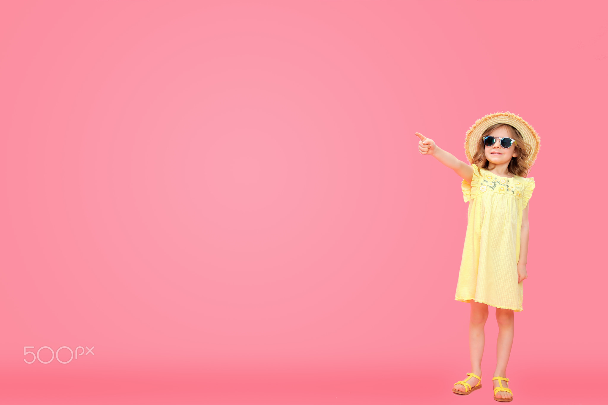 Little girl in dress pointing away