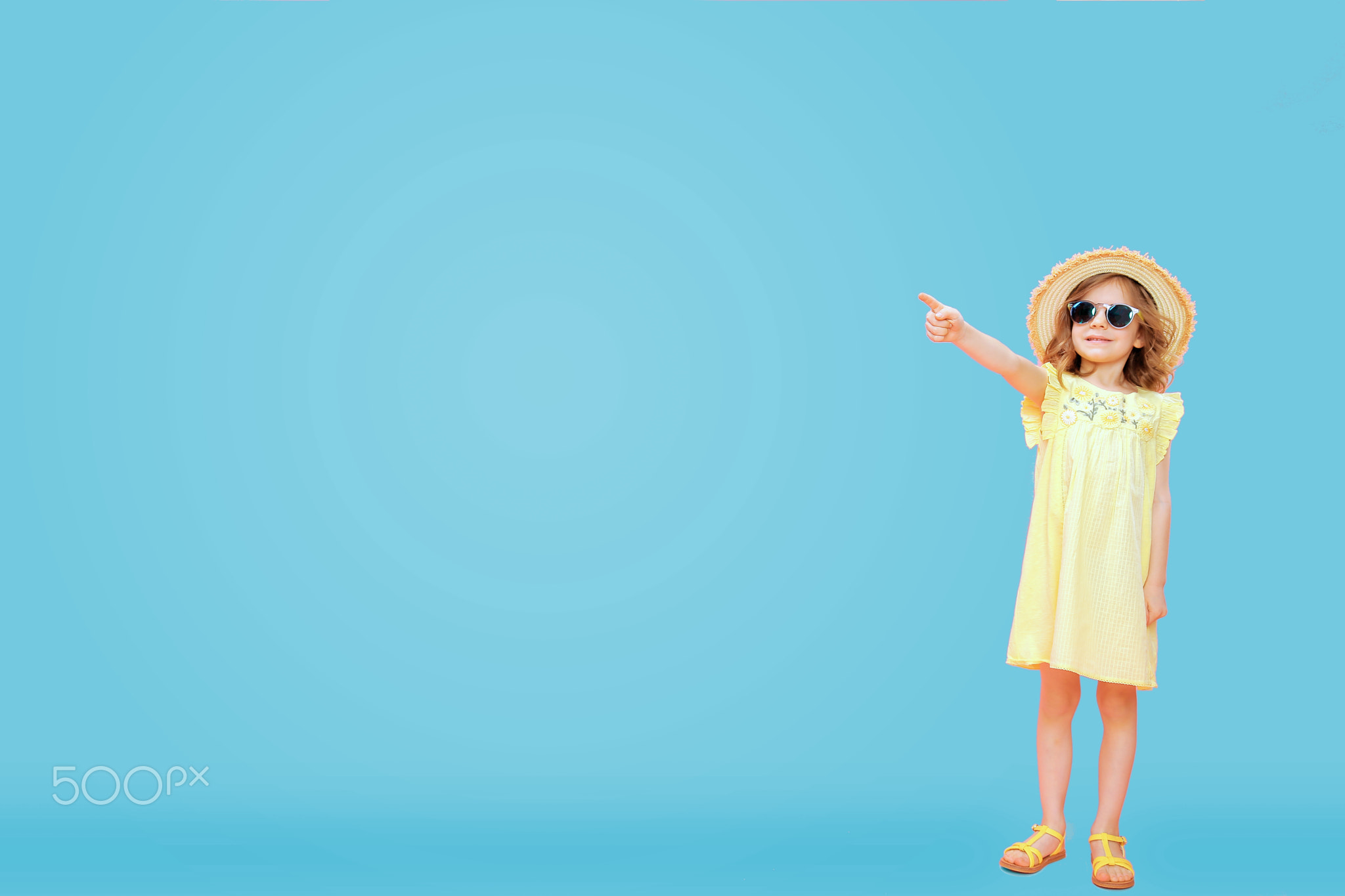 Little girl in dress pointing away