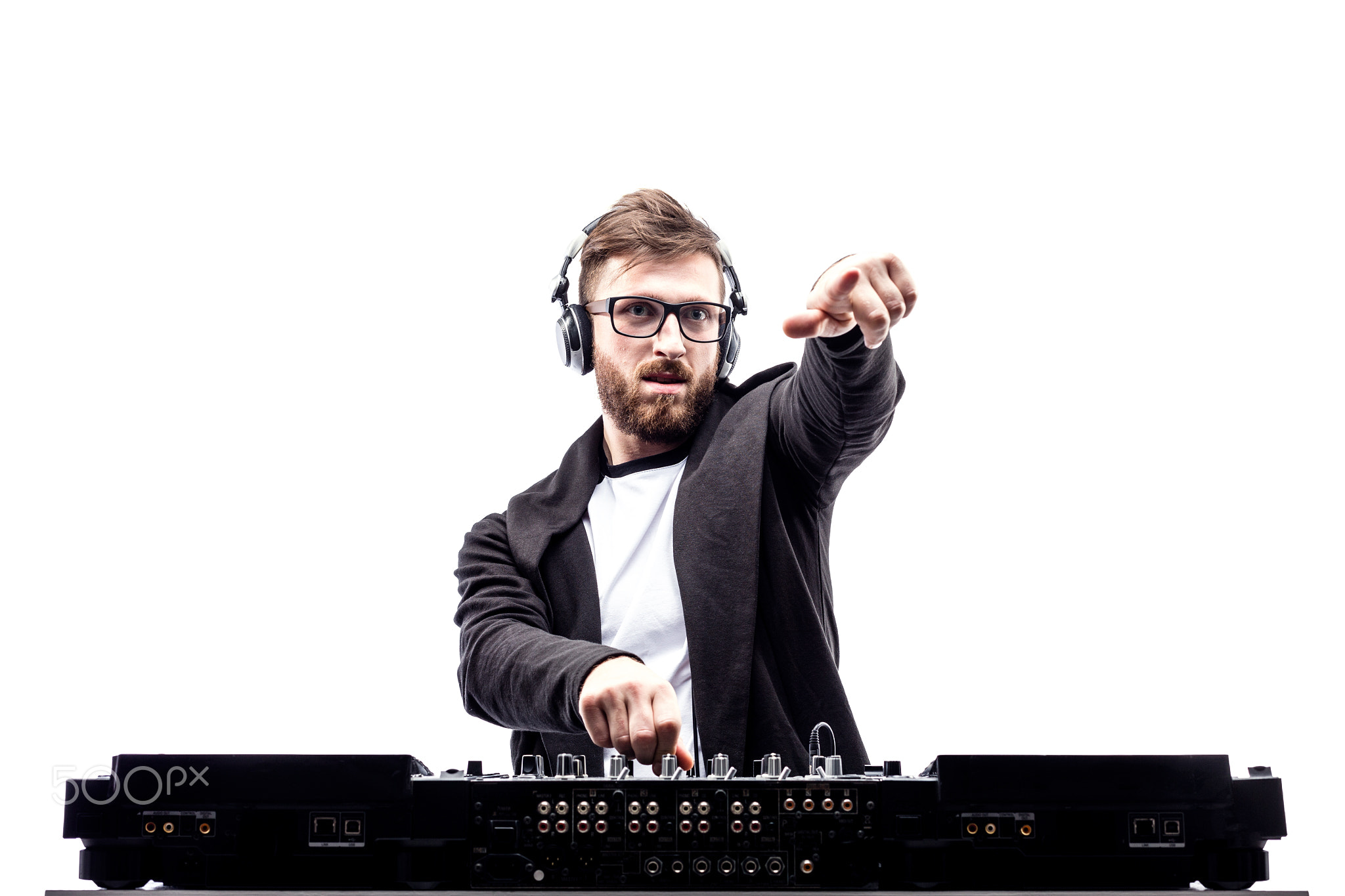 Trendy male dj posing against mixing console