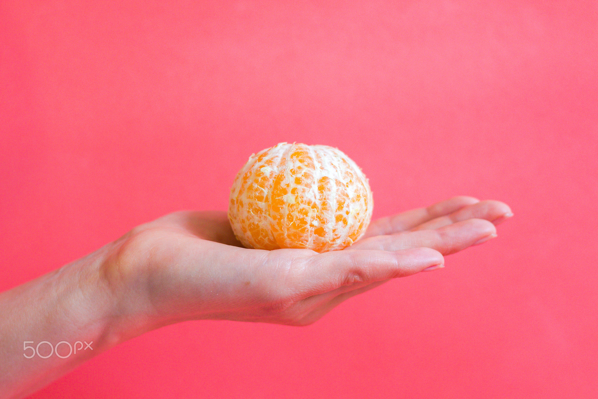 The peeled mandarin lies on a gentle female hand
