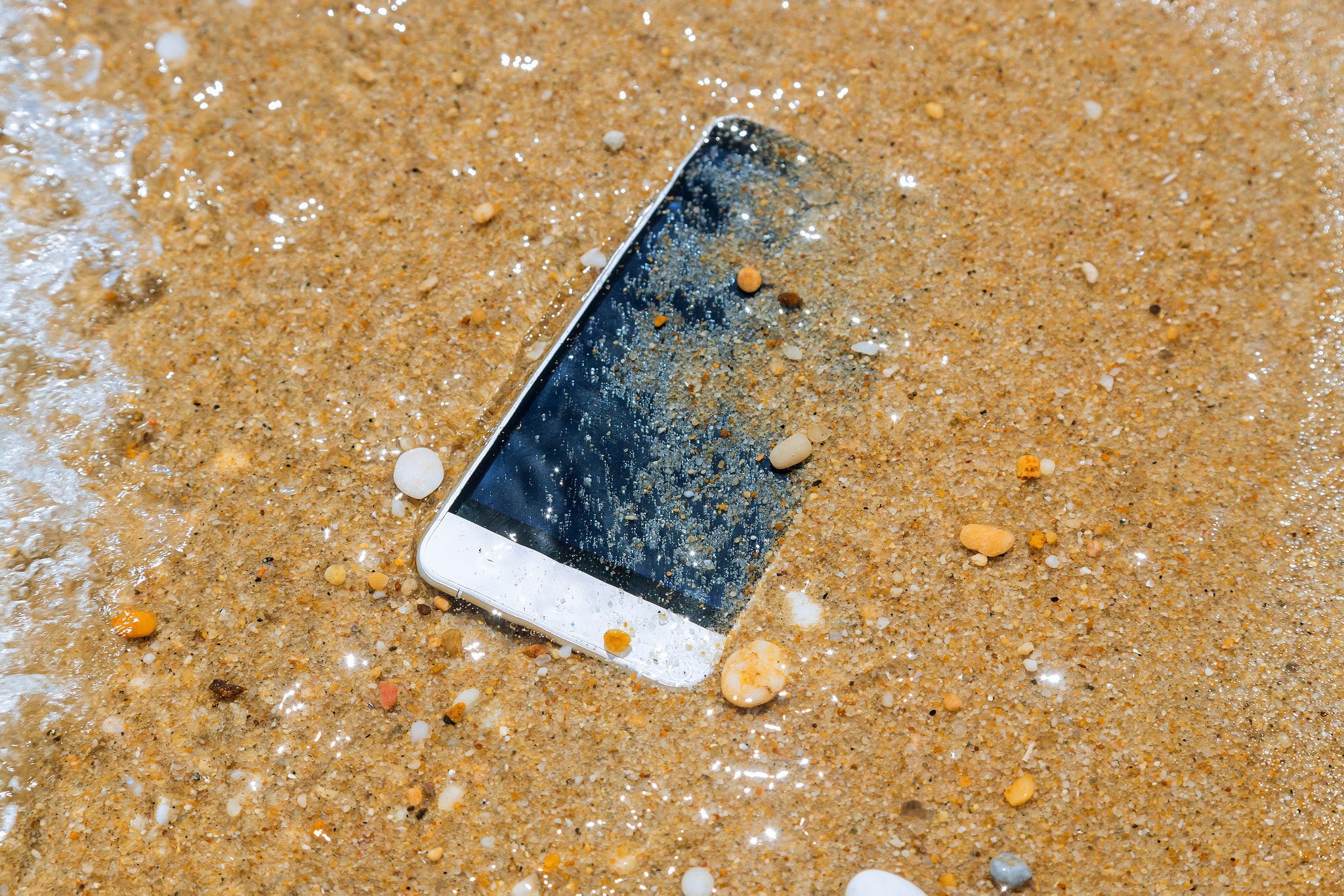 Phone dropped into the water of sea background