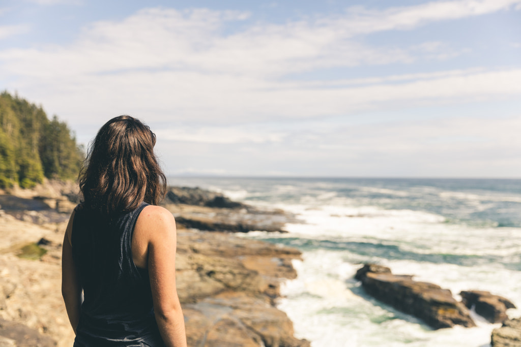 Woman standing on rocky coast by Kaitlyn McLachlan on 500px.com