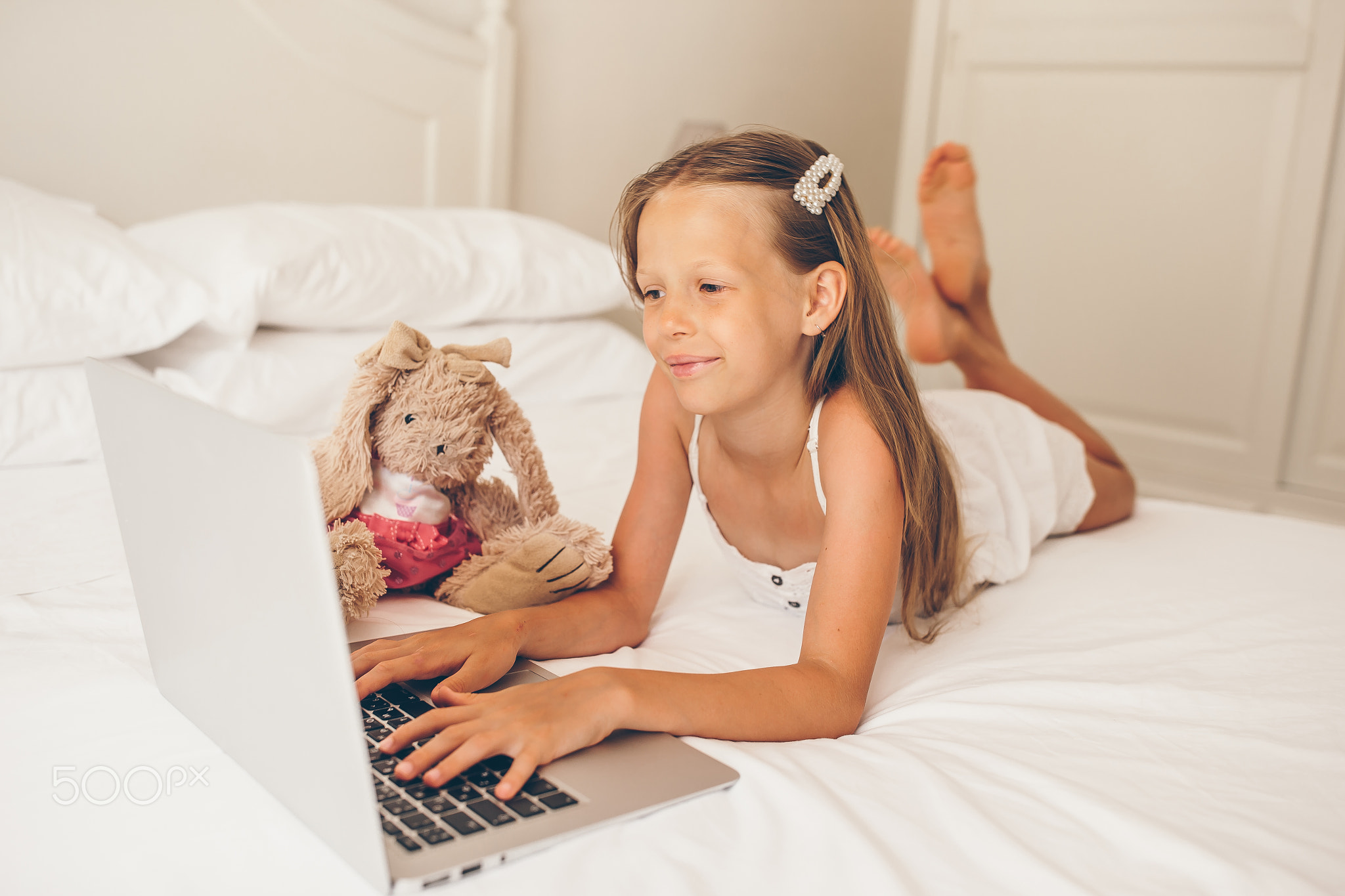 Cute little girl doing homework on laptop