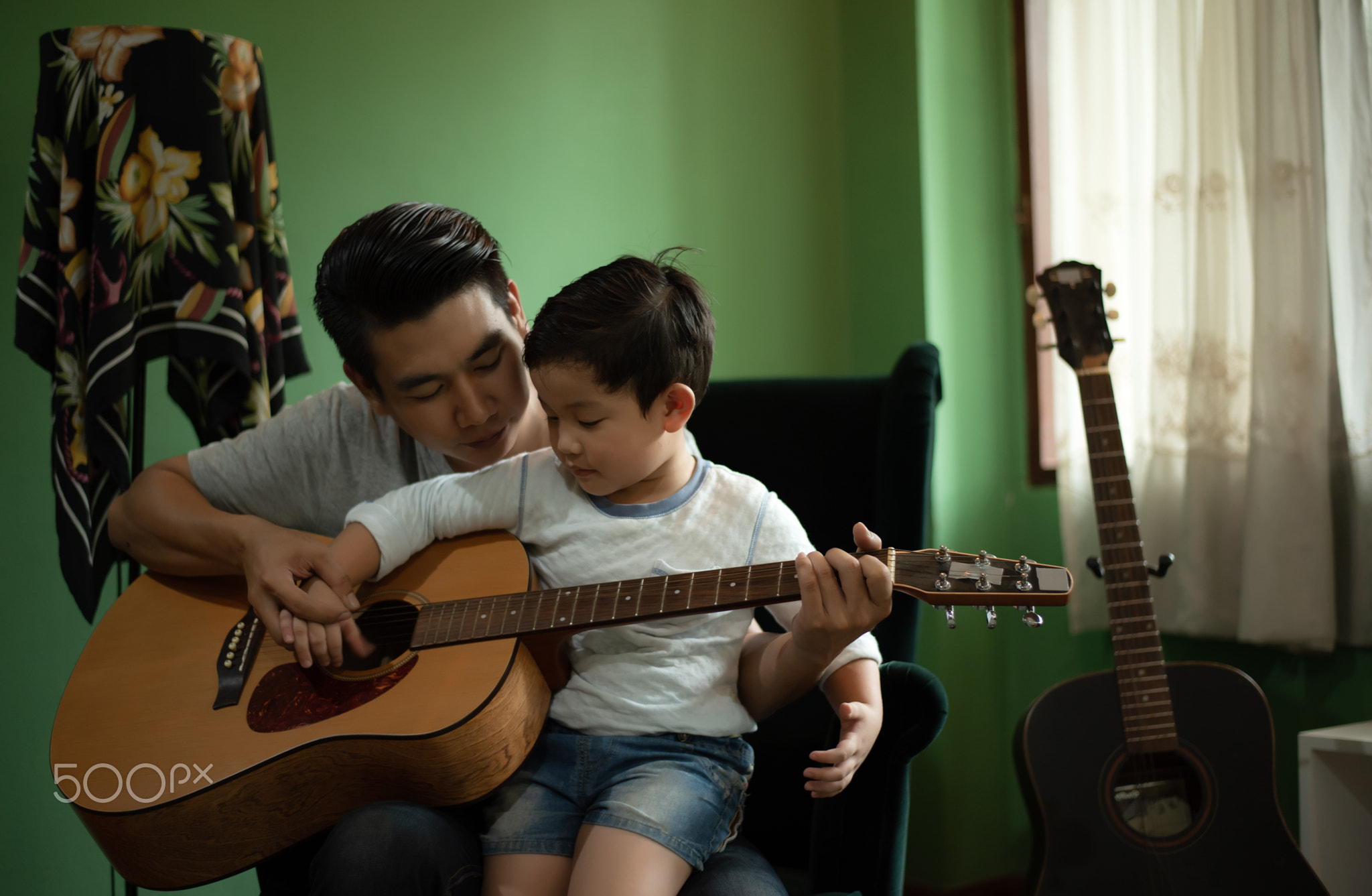 Parent Homeschooling Concept - Asian Family, Father are Teaching Little Boy Playing Guitar and...