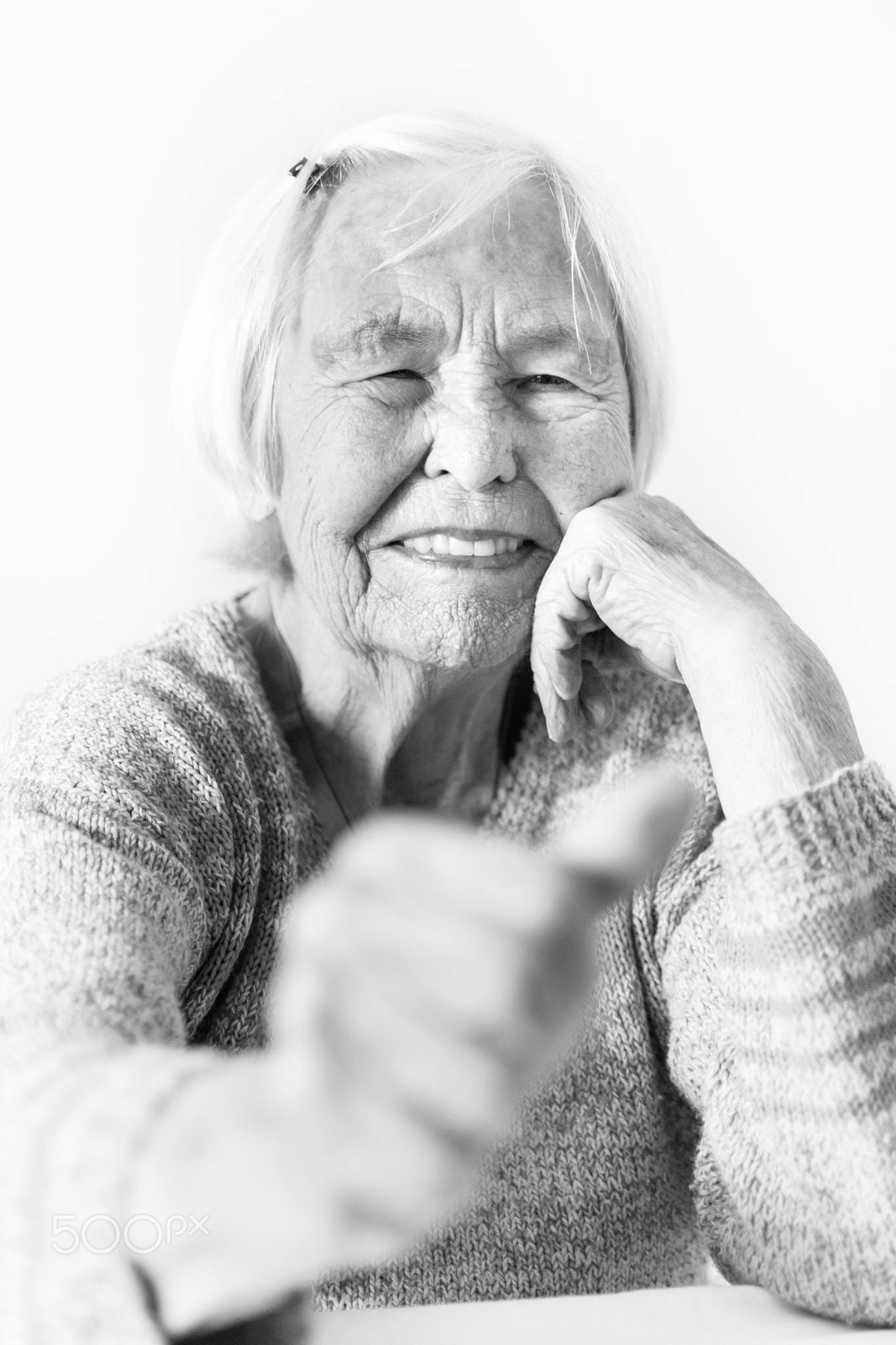 Happy 96 years old elderly woman giving a thumb up and looking at camera.