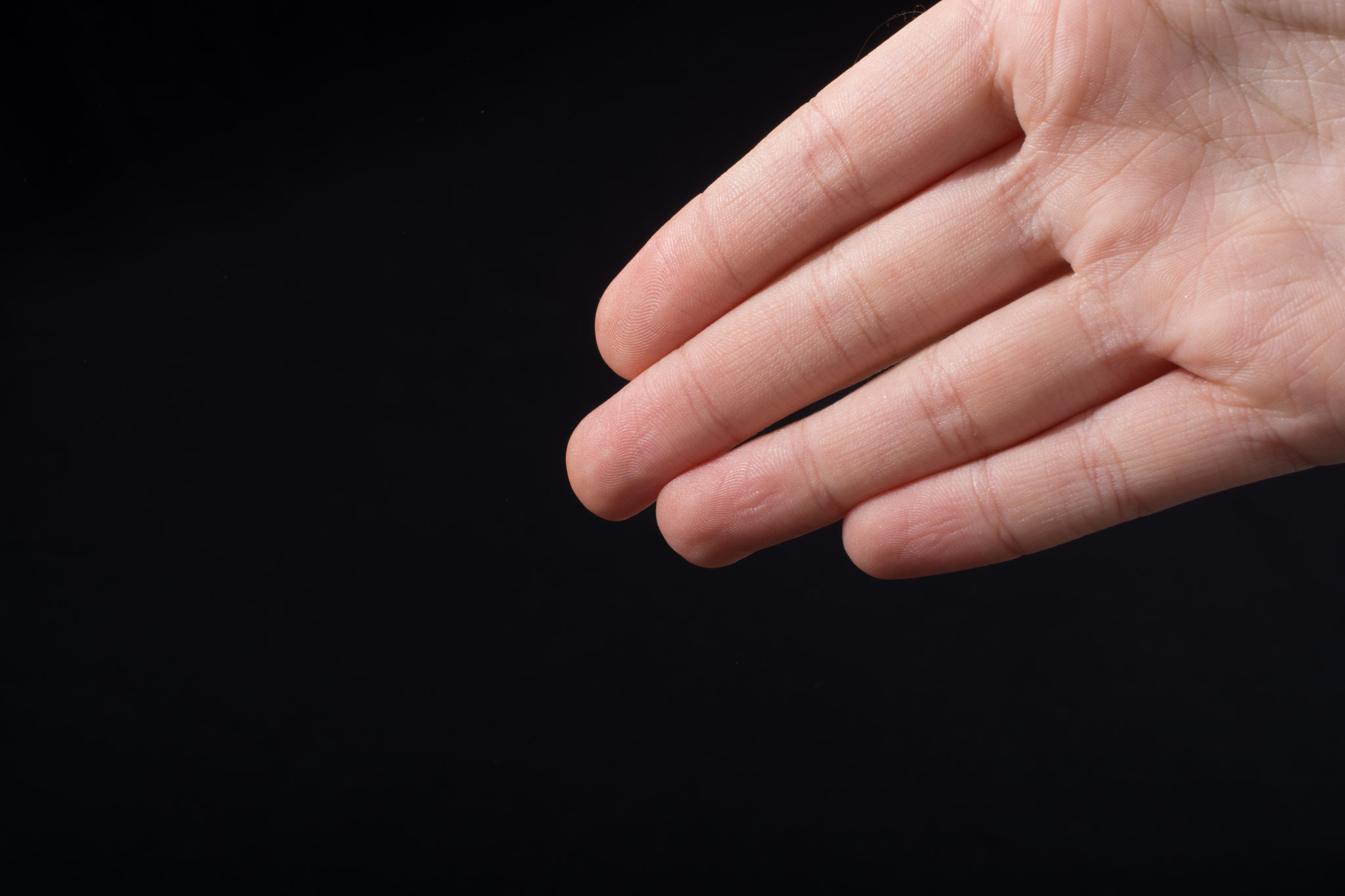 Four fingers of a human hand partly seen in view