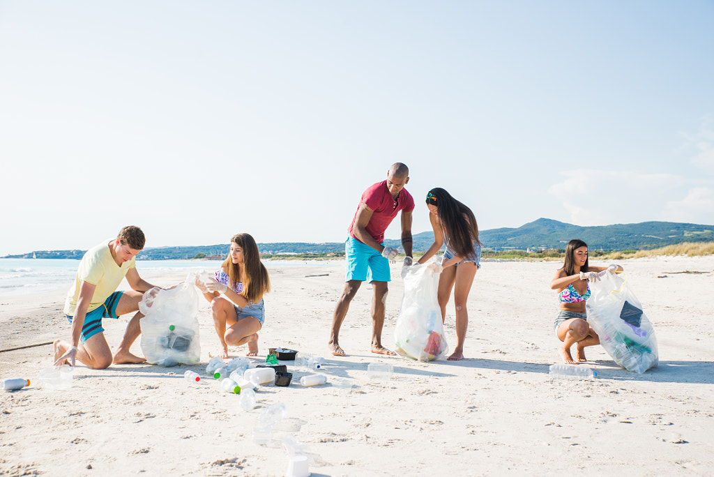 Group of activists friends collecting plastic waste on the beach by Cristian Negroni on 500px.com