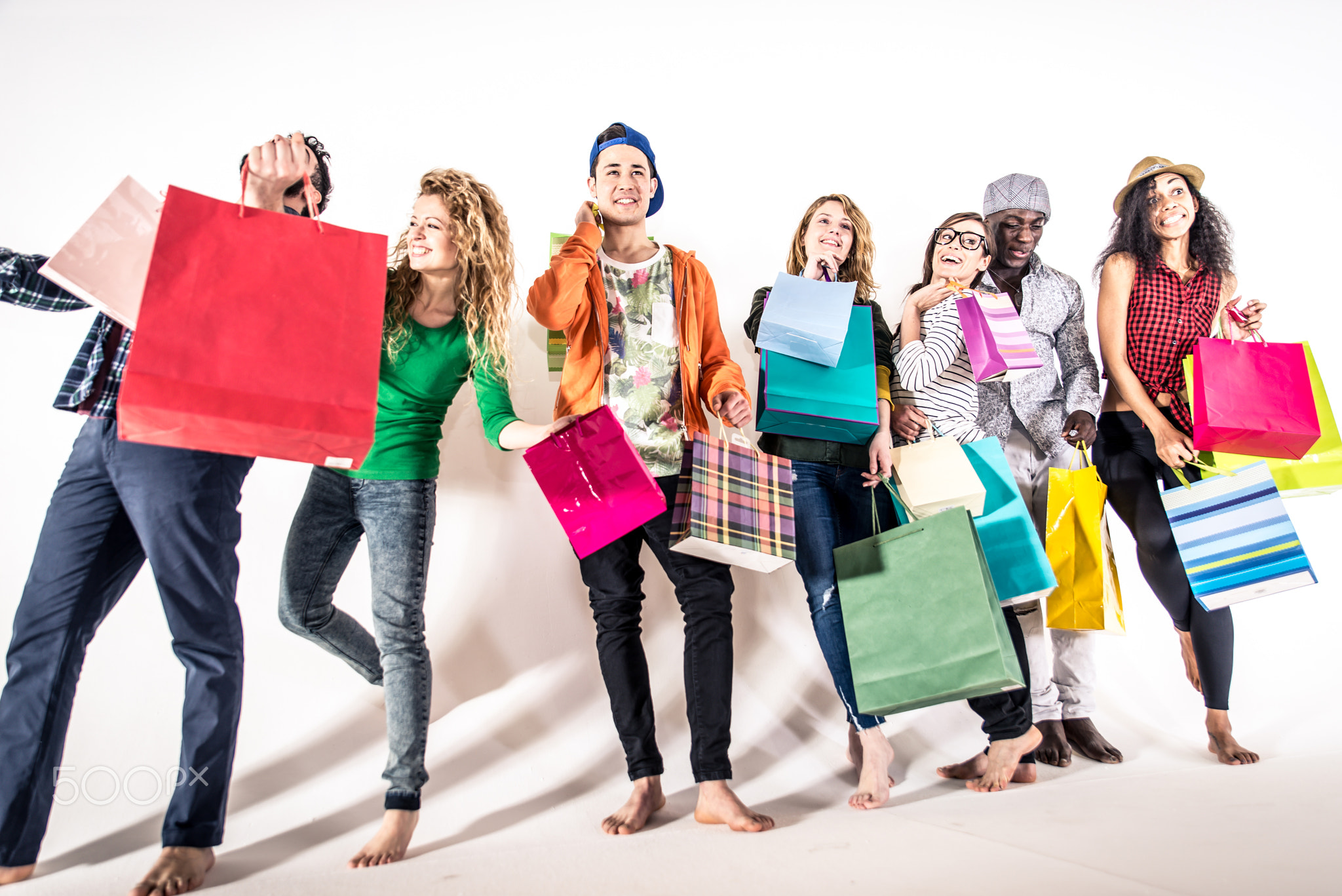 Multi-ethnic group of people holding colored shopping bags and l