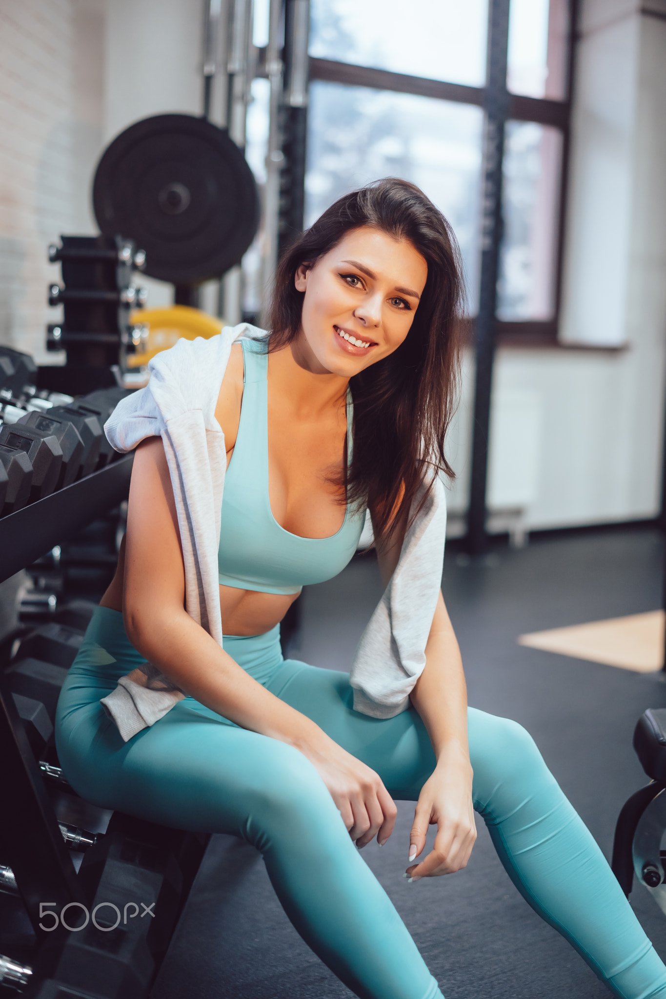 Young adult girl posing on camera in the gym