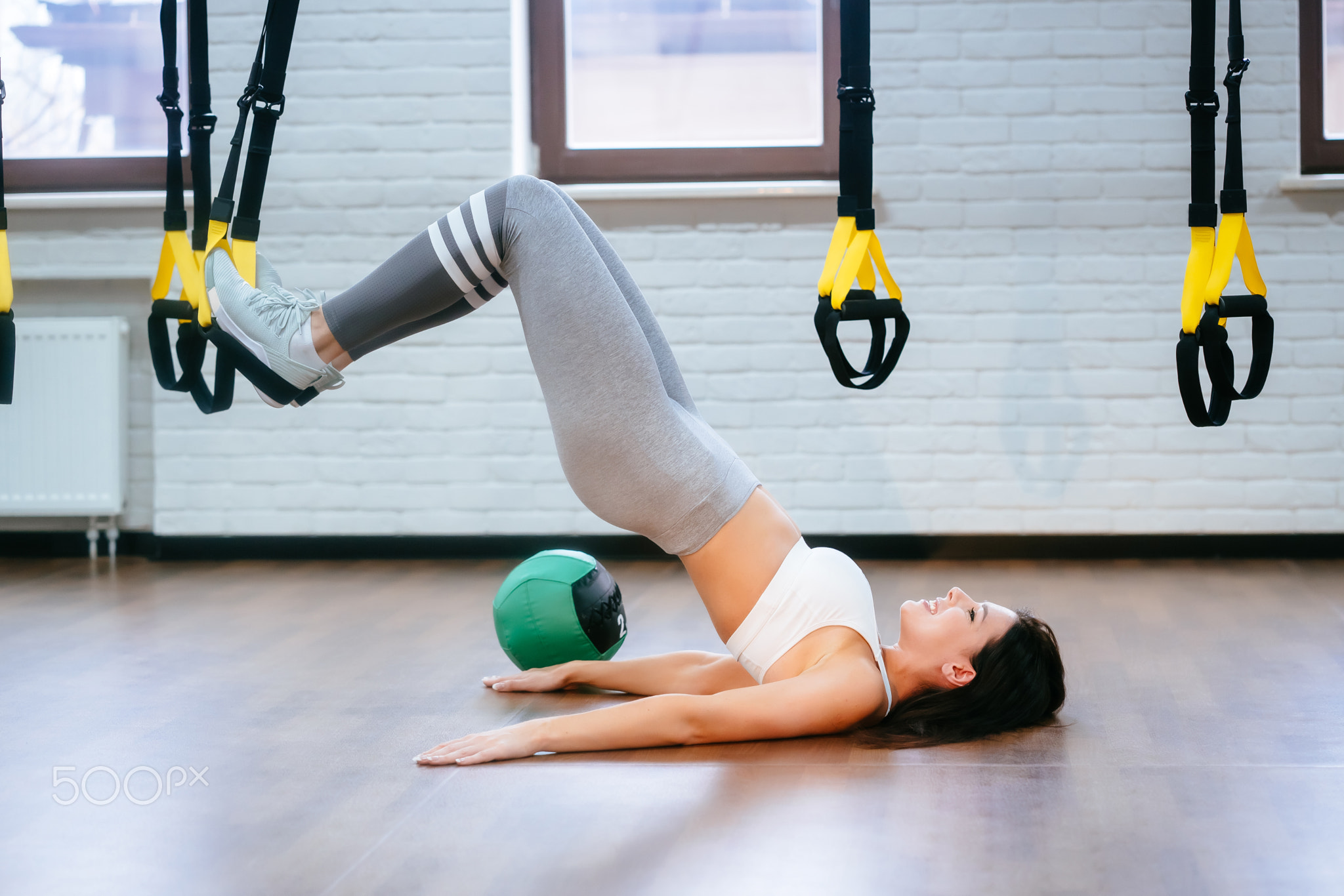 Young adult girl doing exercises in the gym