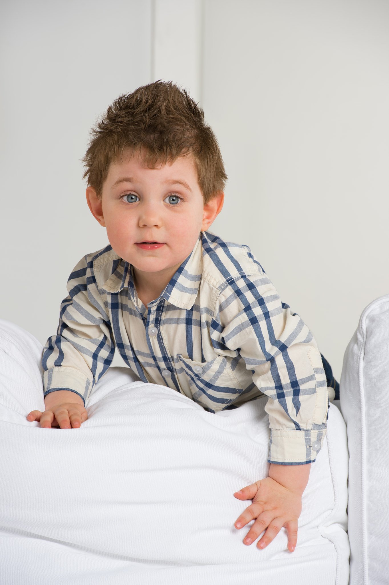 Cute little boy playing at home on sofa
