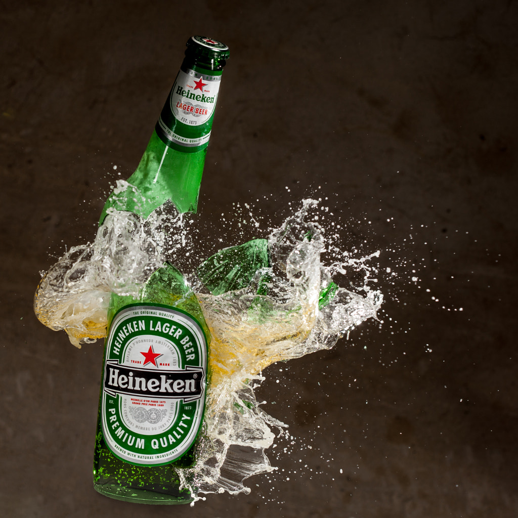 Heineken lager beer bottle broken by Tomislav Kovacevic / 500px