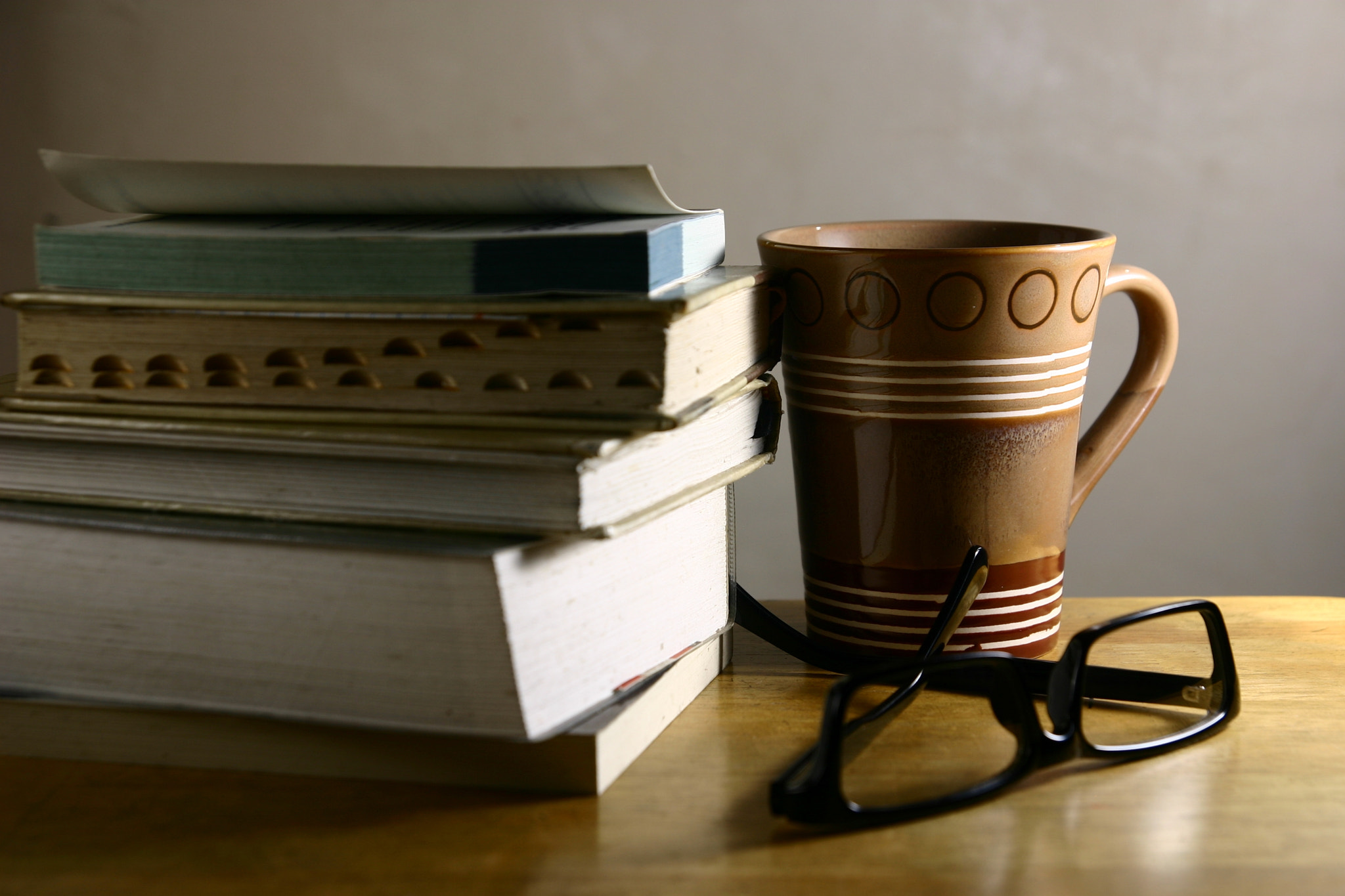 eyeglasses, books and coffee mug