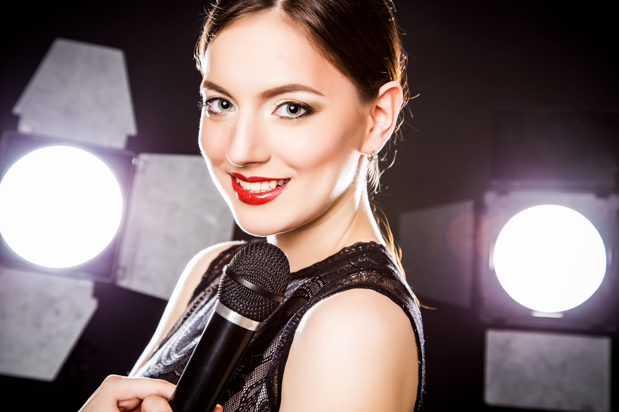 Close-up portrait of beautiful elegant young woman with microphone