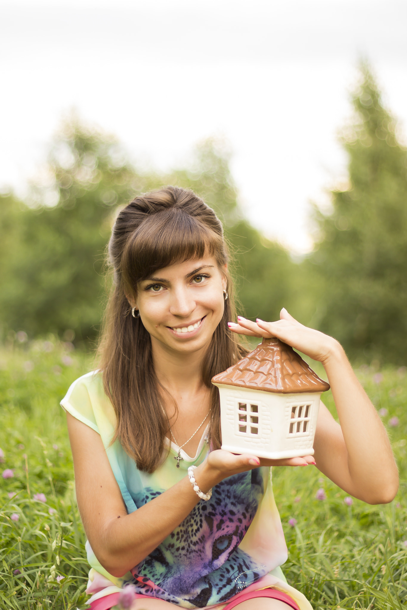 Woman holding a toy house in garden