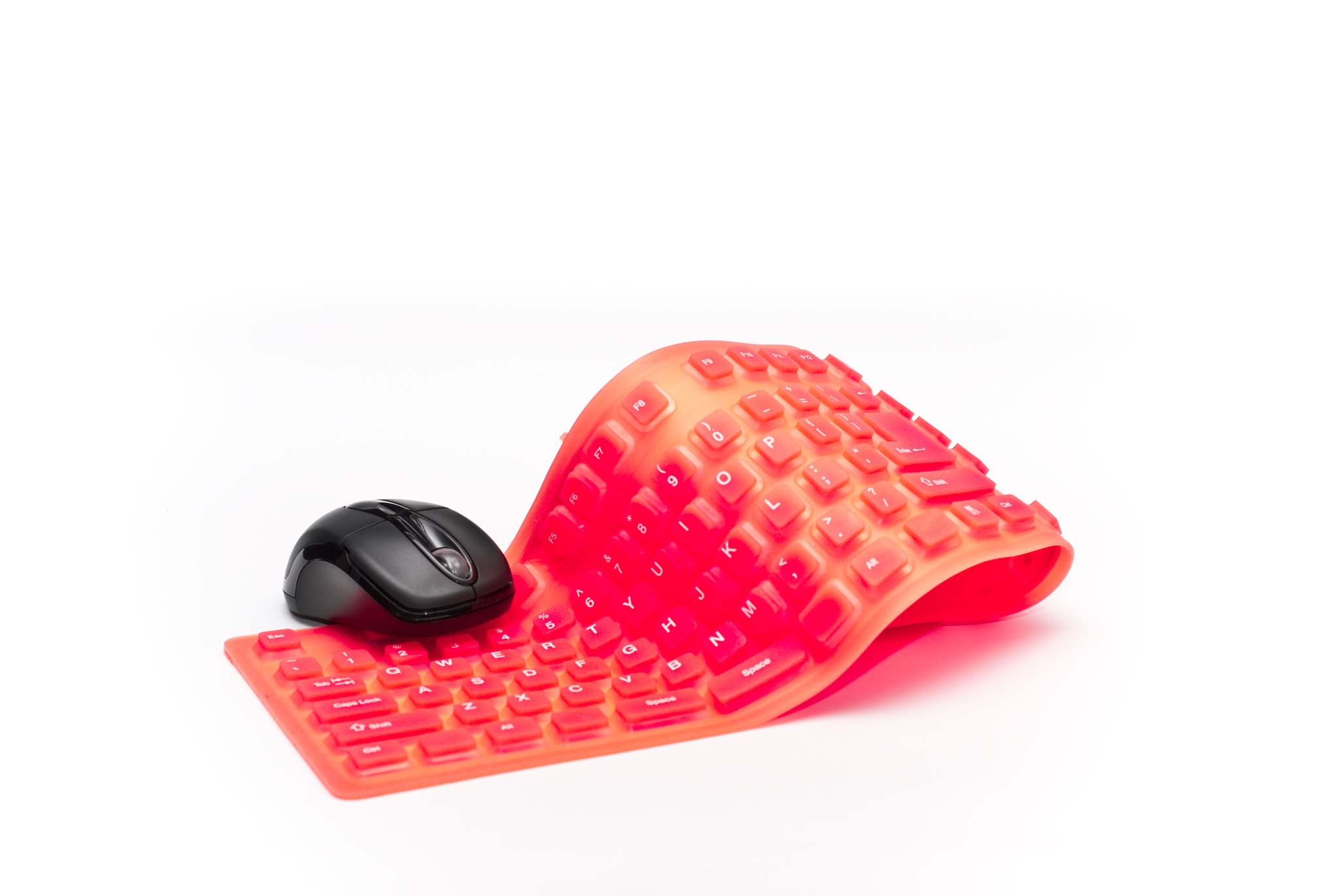 magenta flexible keyboard with black mouse isolated on white background