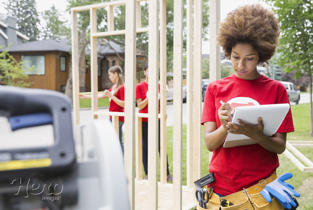 Volunteer with notepad near construction frame by Hero Images Hero Images on 500px.com