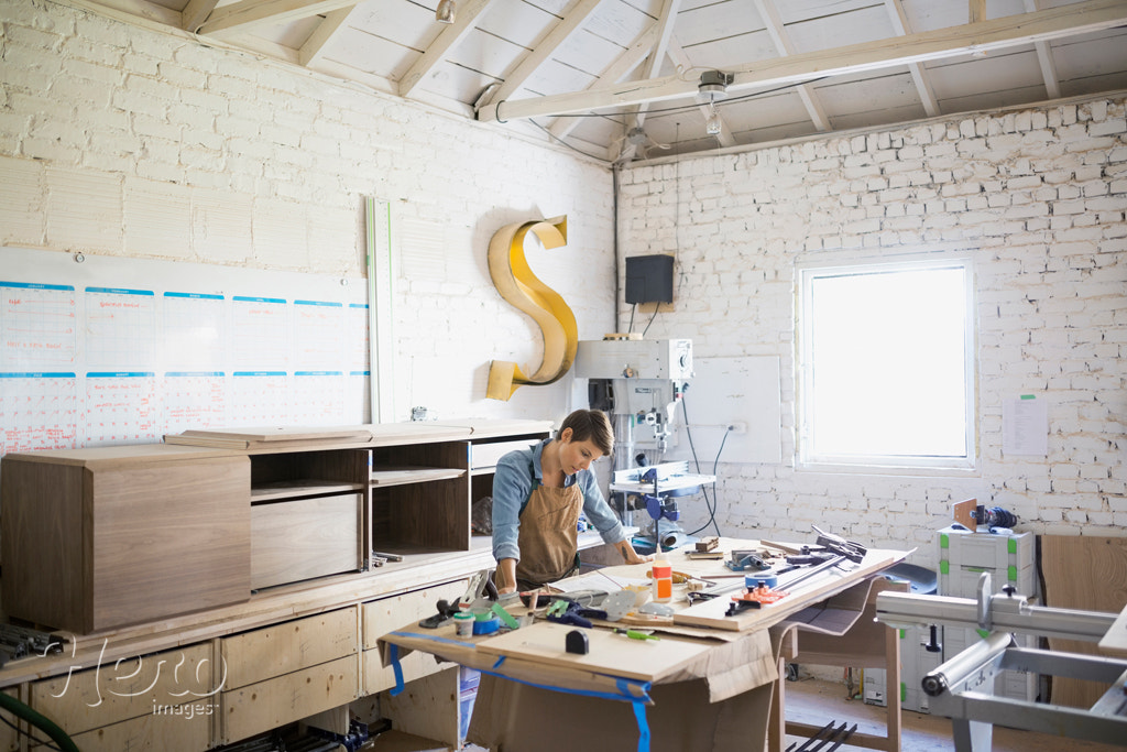 Female carpenter at workbench in workshop