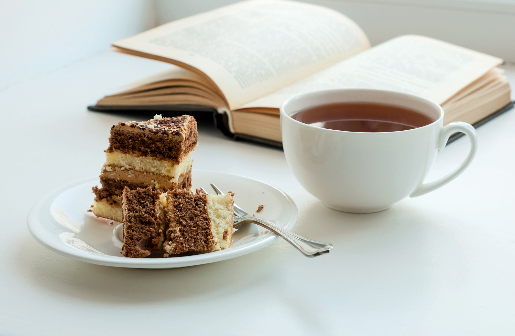 Cup of tea, cake and some books to read lying on the table