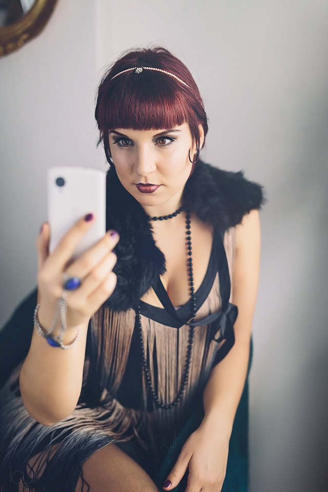 Vintage flapper girl using a modern smartphone